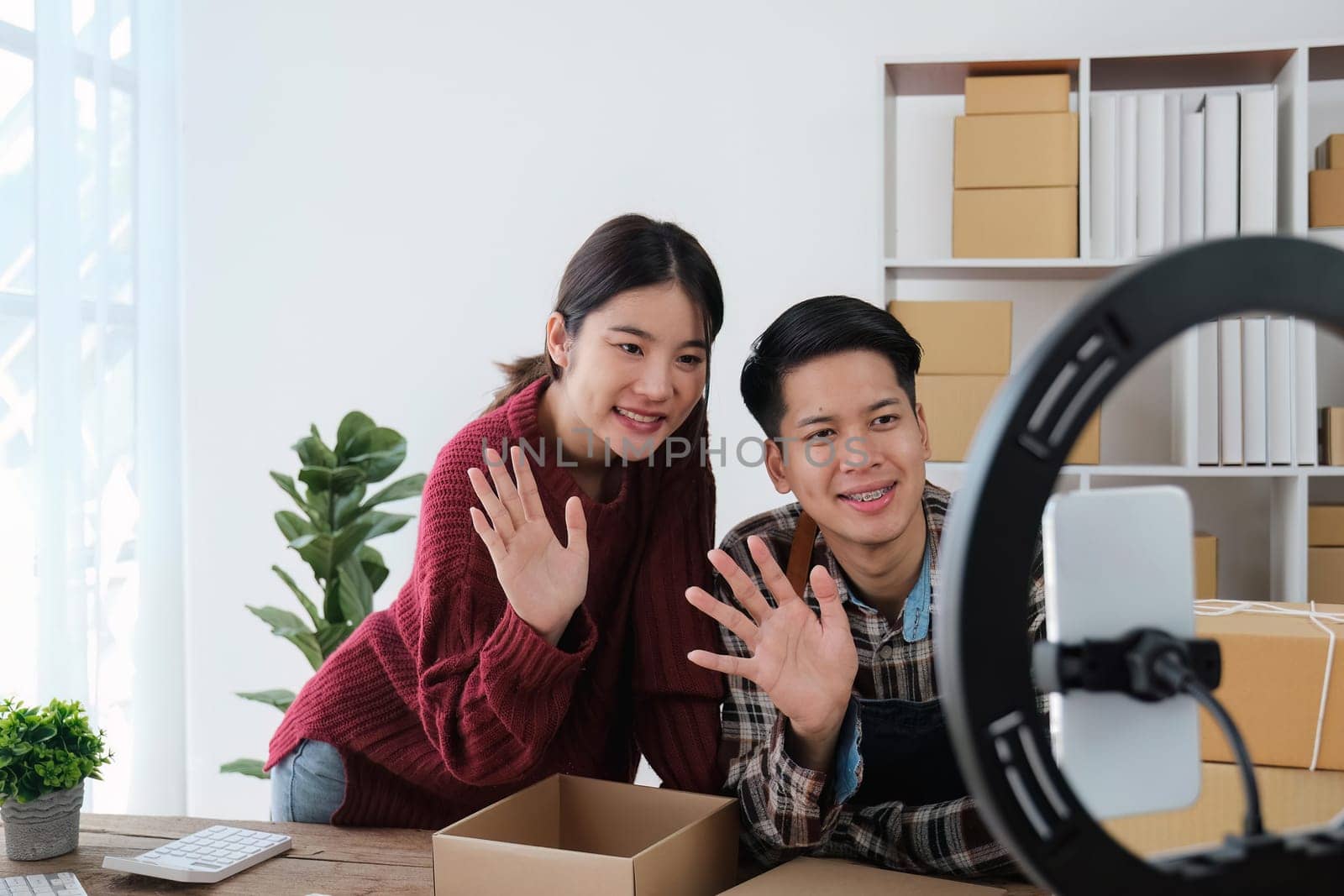 young couple mobile phone recording live streaming in online social media selling products by couple, doing freelance, own business or entrepreneur at home. E-commerce, shopping concept.