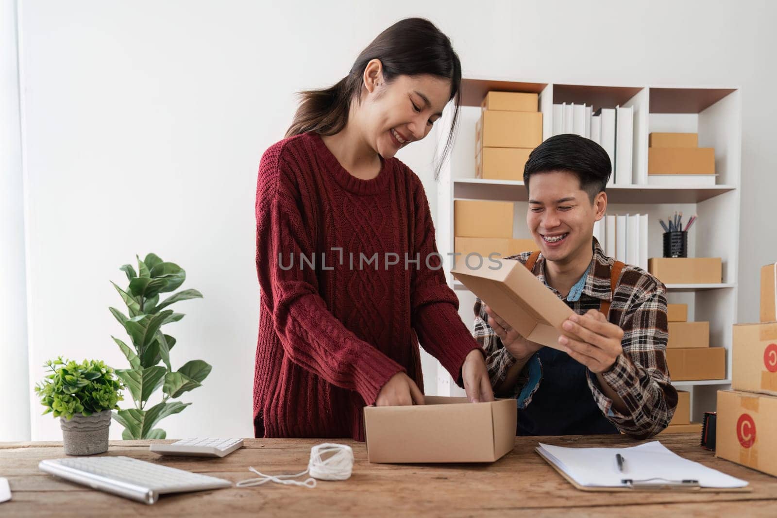 startup small business owner working with computer at workplace. freelance man and woman seller check product order, packing goods for delivery to customer. Online selling, e-commerce.