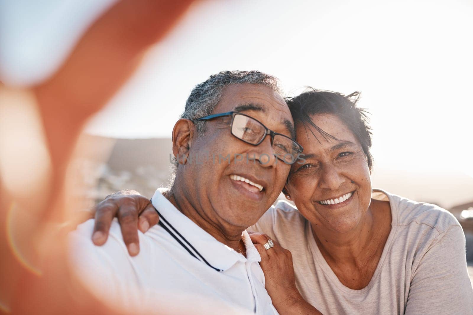 Selfie, romance and a senior couple on the beach together during summer for a retirement holiday or vacation. Portrait, smile or dating with an old husband and wife posing for a photograph by the sea.