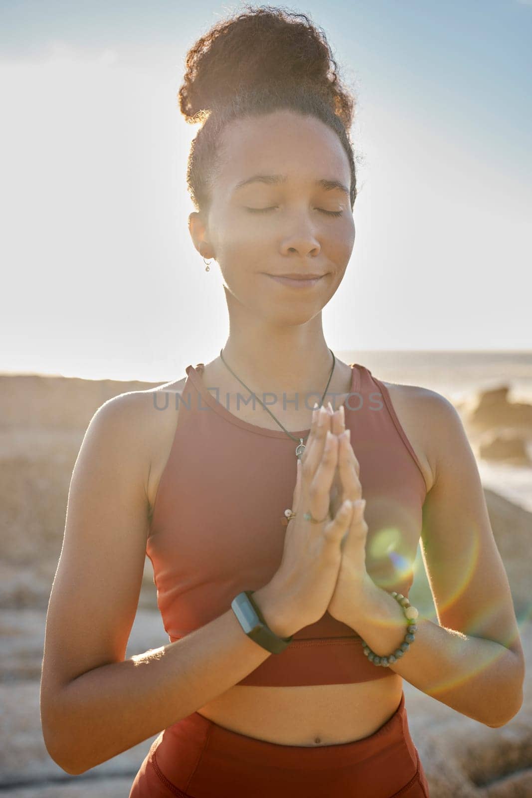 Meditation, calm and woman doing exercise at the beach for wellness, peace and relaxation. Nature, fitness and black woman with hands together doing workout for zen, mental health and energy by ocean.