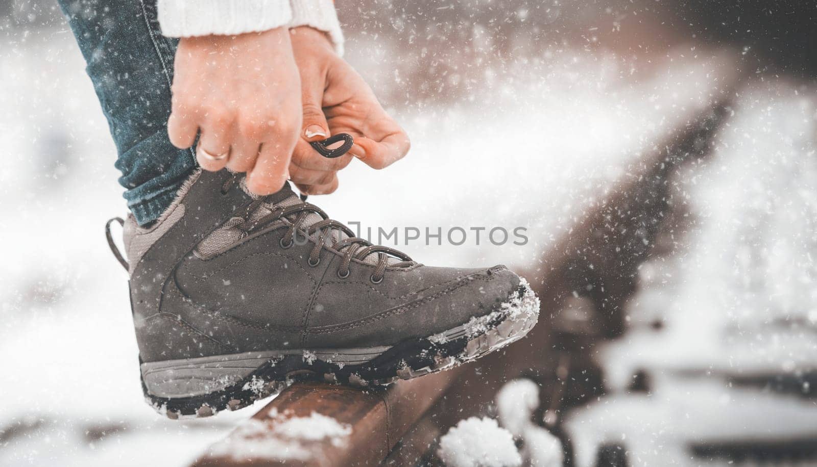 Girl tying shoe laces on the rails in winter