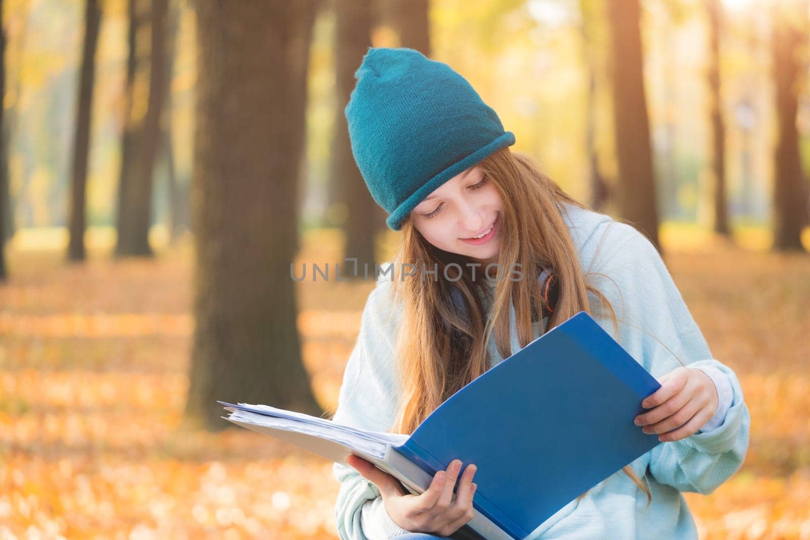 Cute girl studying in autumn park
