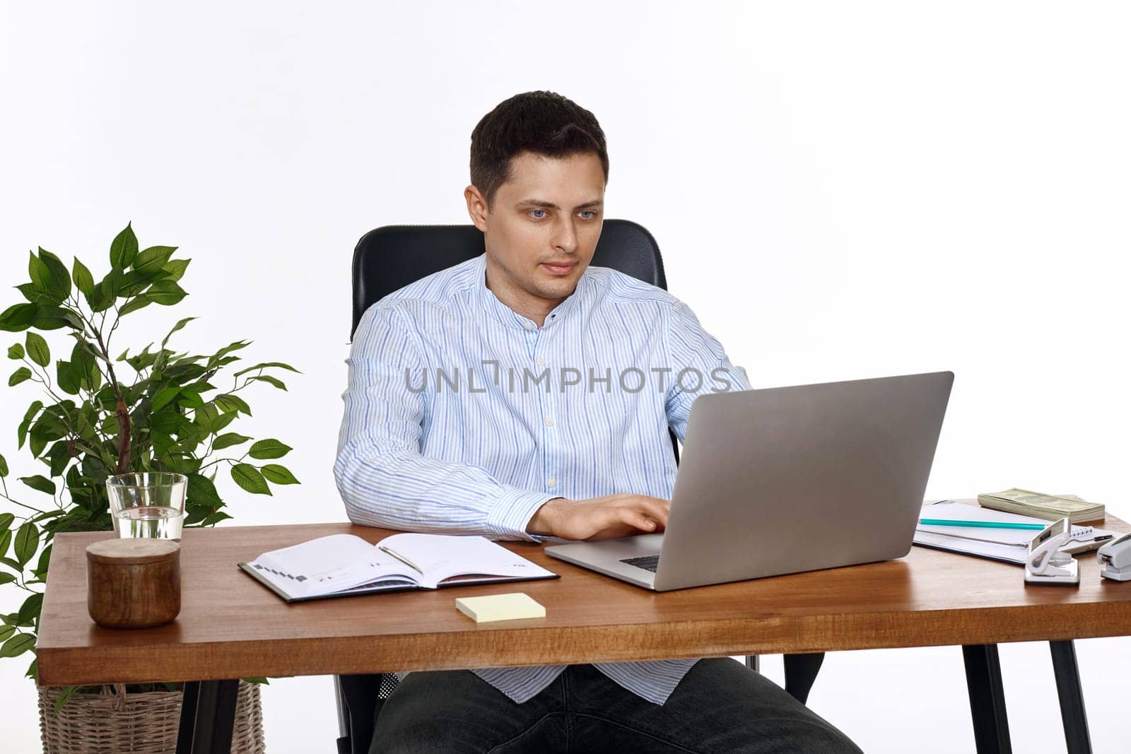 young man using laptop computer for online work at table on white background