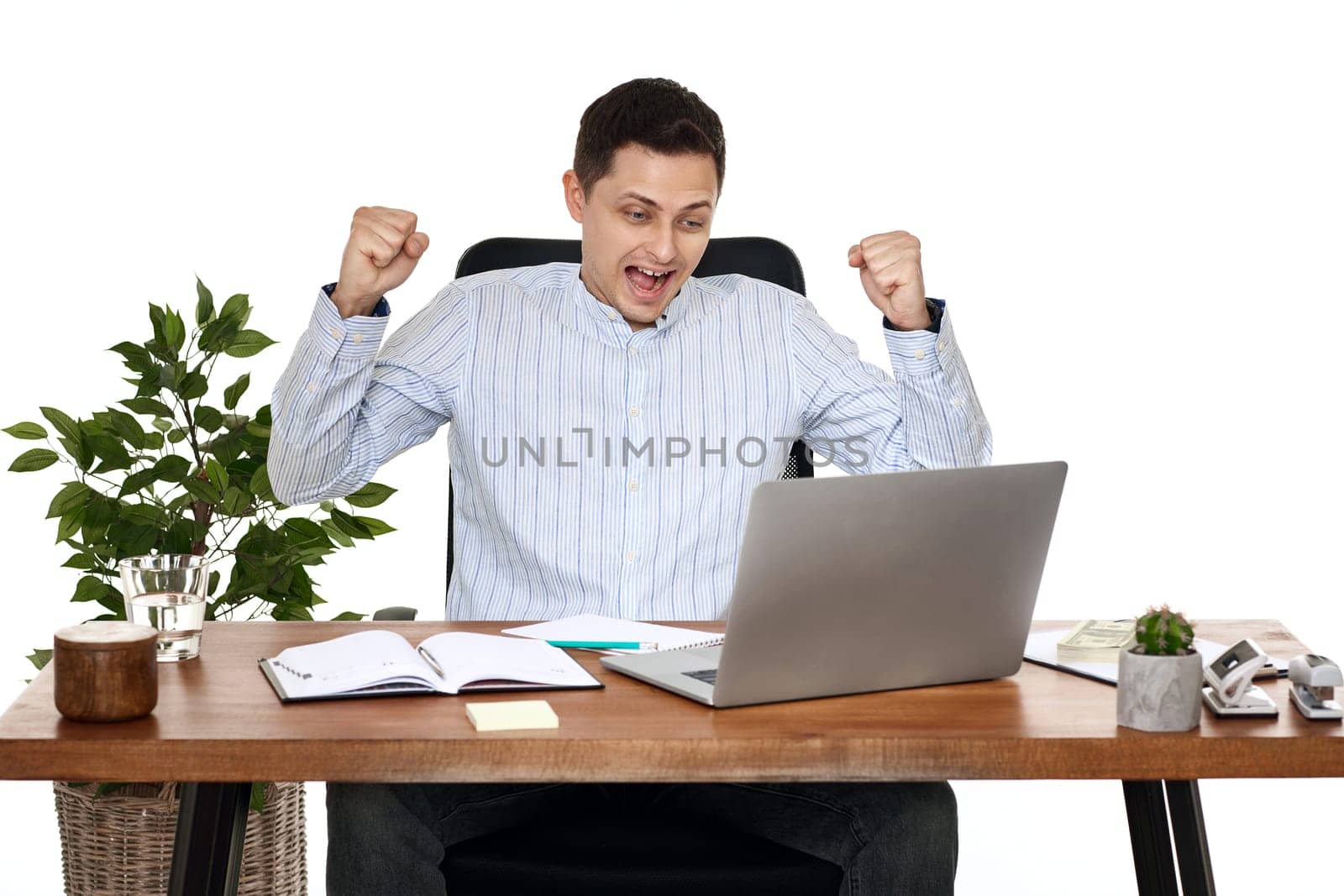 Satisfied businessman gesturing emotionally and celebrating victory in the office