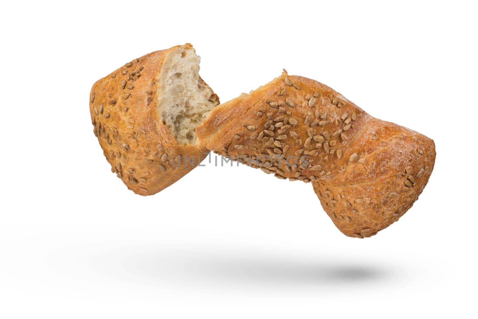 Fresh loaf of light bread on a white isolated background. Healthy food concept. A loaf broken in half, isolated on a white background, casts a shadow. Side view.