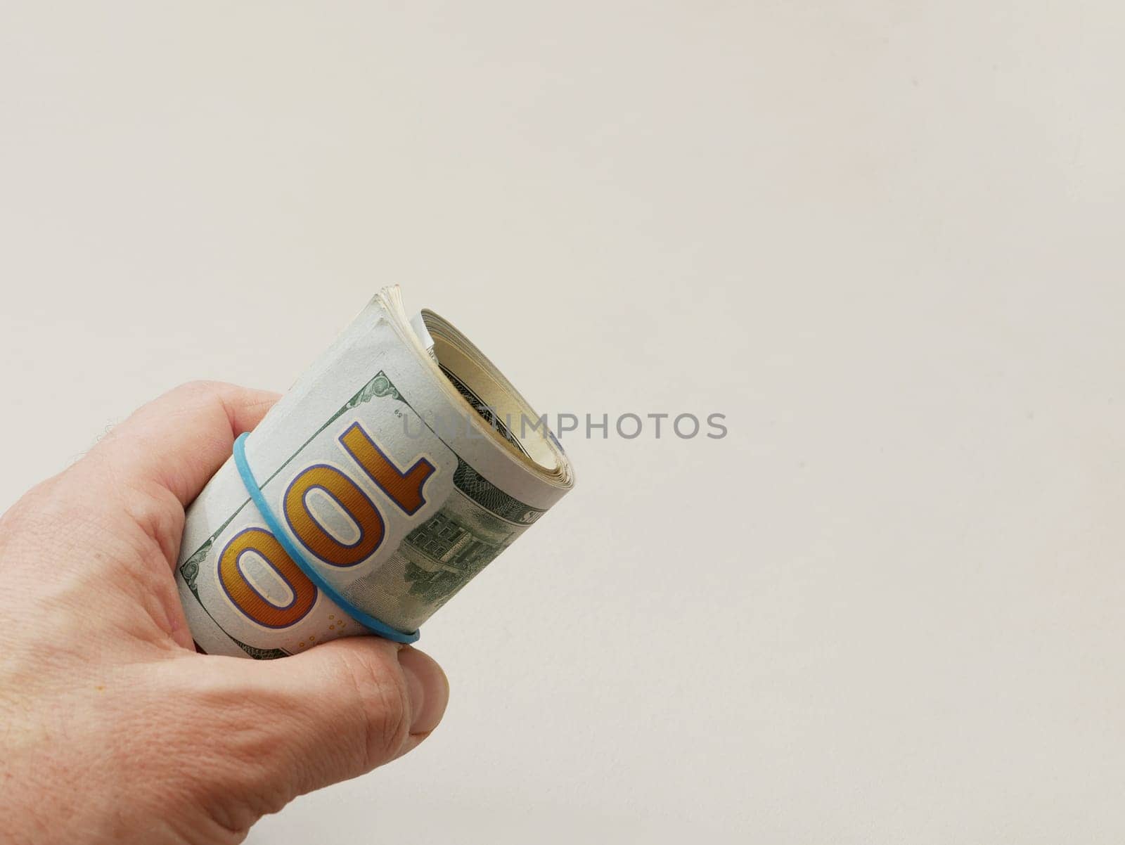 A man's hand holds a hundred dollar bill. by gelog67