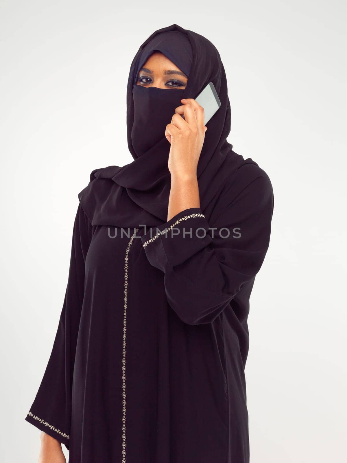 Muslim woman on a phone call in studio global, international communication of culture and design. Islam, arabic and traditional model talking on smartphone for networking isolated on white background by YuriArcurs