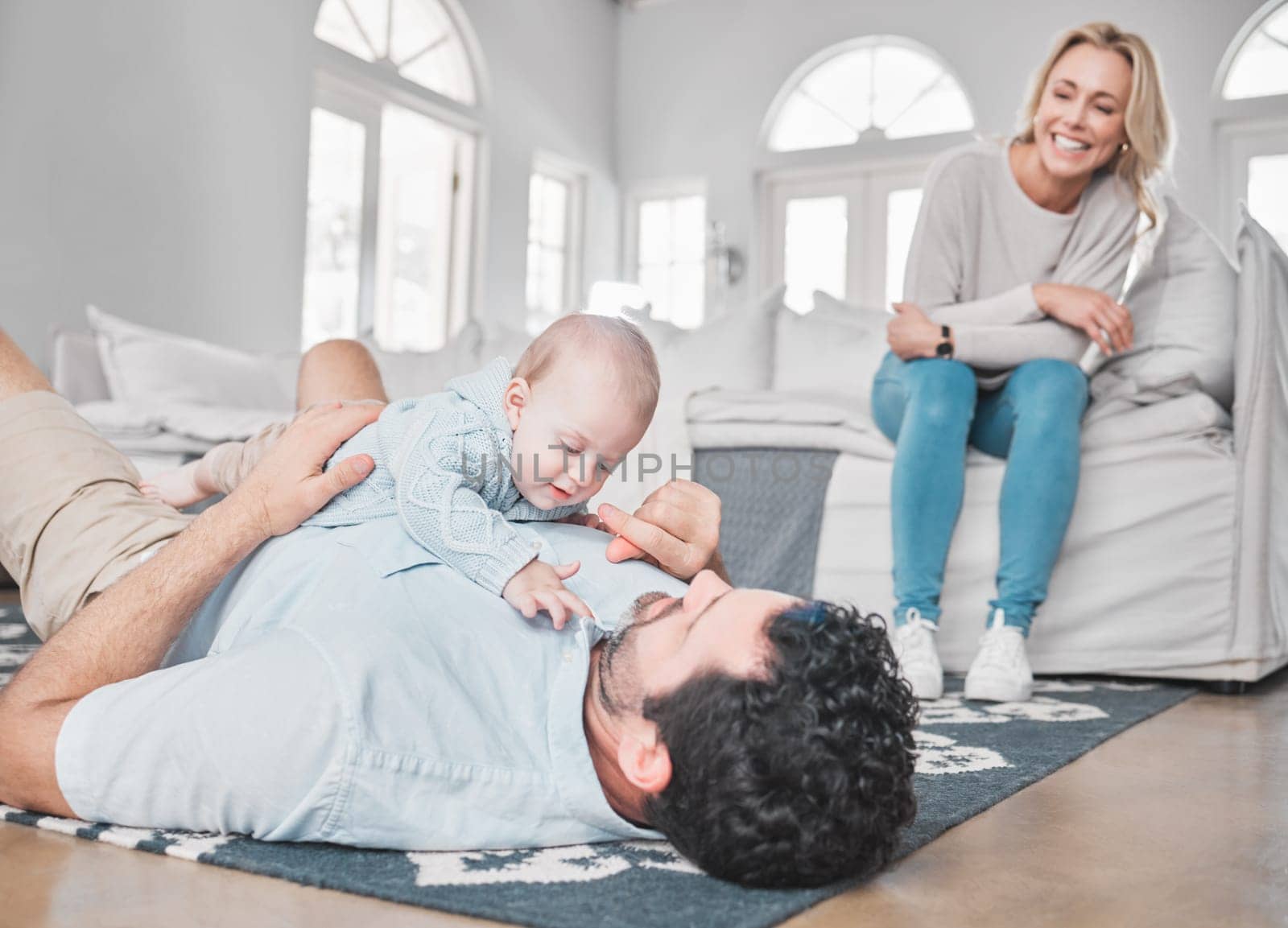 Care, bonding and parents with baby in the living room of their house. Playful, happy and mother and father with love for a child while playing with affection on the floor of the lounge as a family.