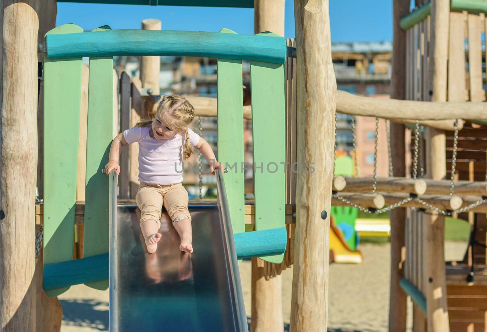 Girl of three years old sliding outdoor Playground