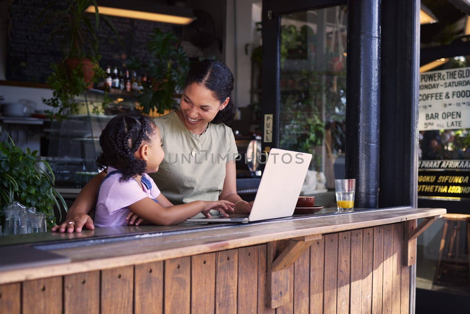 Black family, coffee shop or laptop with a mother and daughter together in the window of a restaurant. Kids, computer or education with a woman and female child sitting or bonding in a internet cafe.