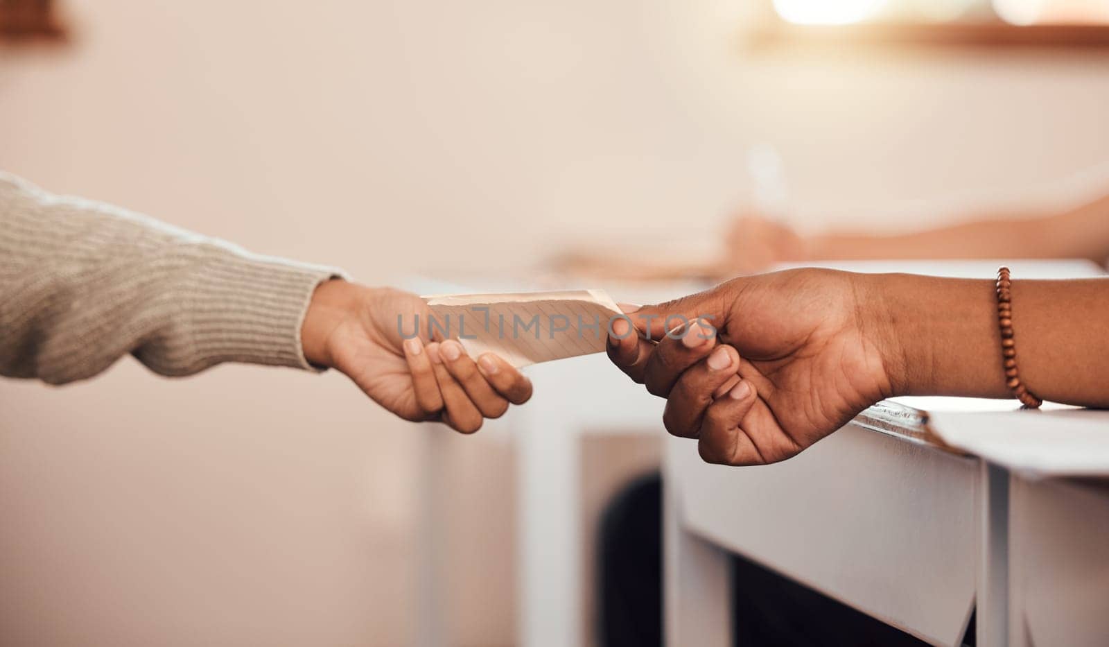 Hands, students pass note in classroom, communication and secret at school with message on paper. Education, learning and people in class for lesson, scholarship and academic with letter writing