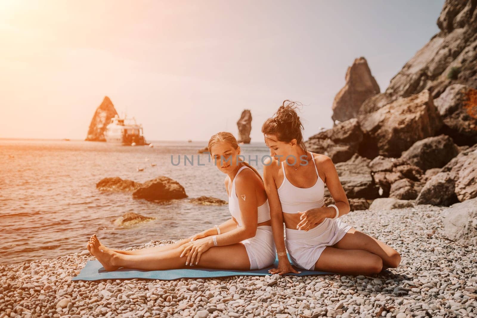 Woman sea yoga. Back view of free calm happy satisfied woman with long hair standing on top rock with yoga position against of sky by the sea. Healthy lifestyle outdoors in nature, fitness concept.