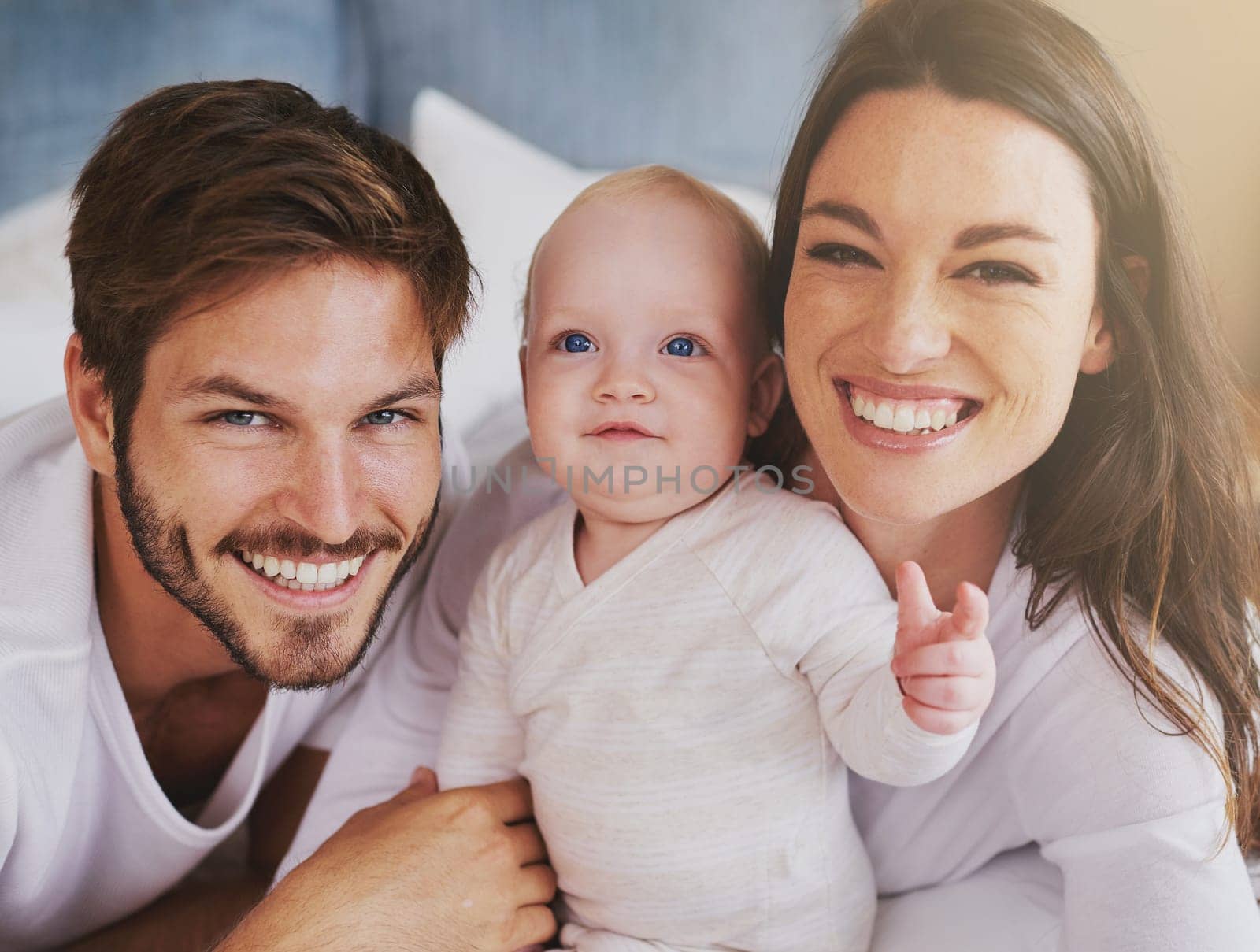 Portrait of happy family, baby and parents with love, care and quality time together at home. Mom, dad and cute newborn kid relaxing with smile, happiness and support of healthy childhood development.