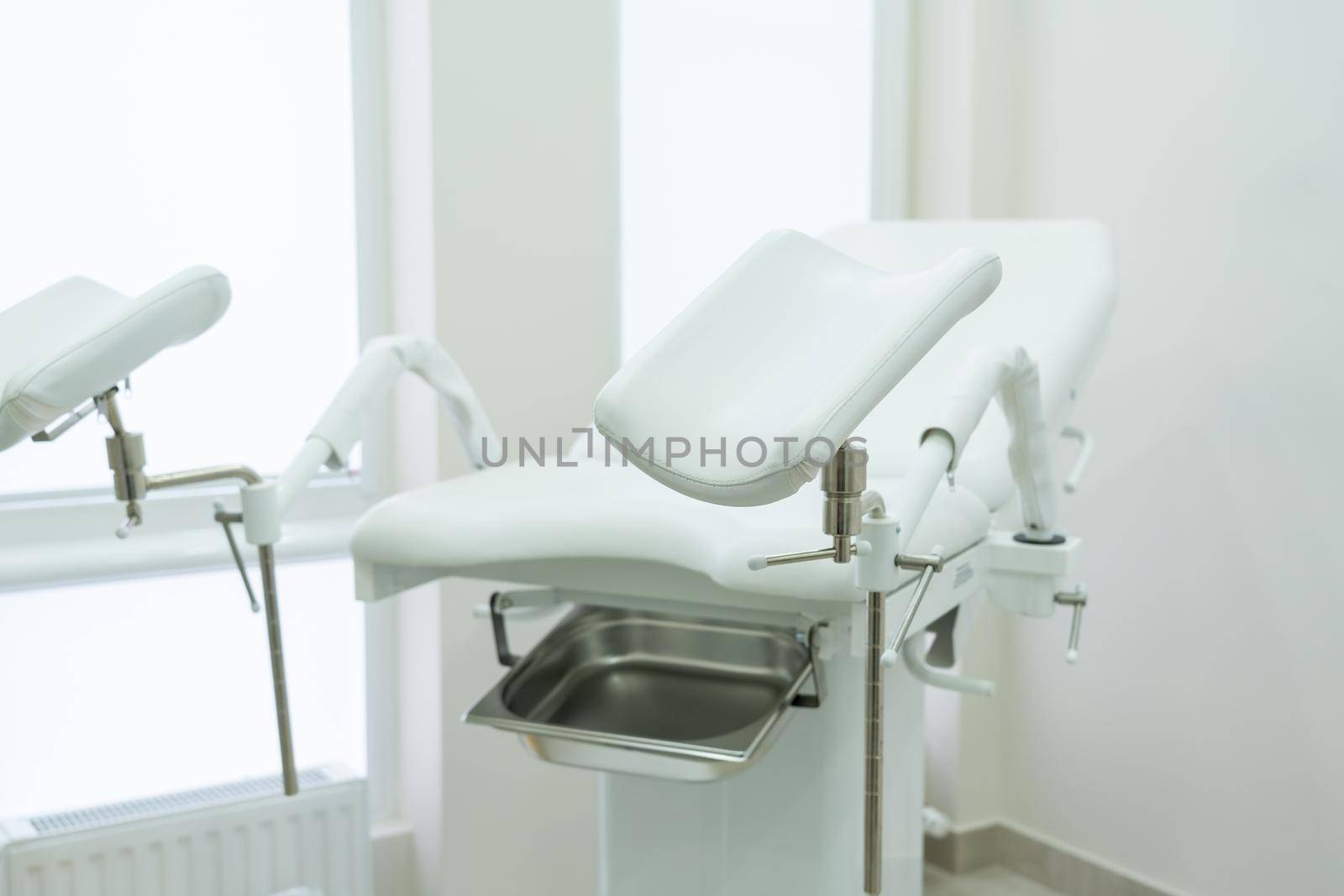 Empty white gynecological chair in a modern medical center