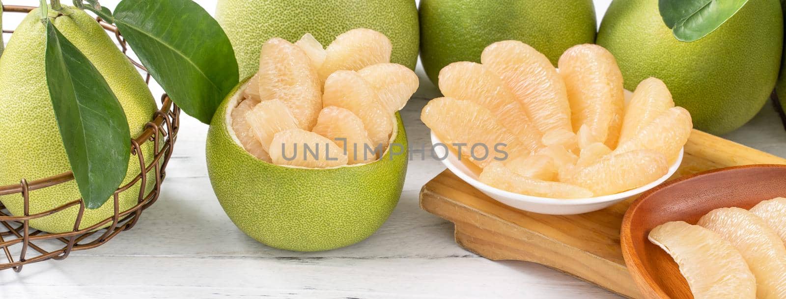 Fresh peeled pomelo, pummelo, grapefruit, shaddock on bright wooden table background. Seasonal fruit for Mid-Autumn Festival, close up, copy space. by ROMIXIMAGE