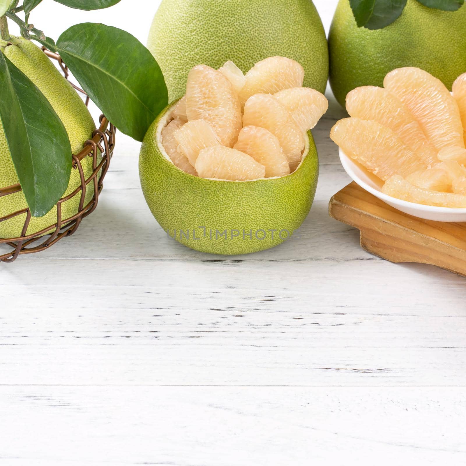 Fresh peeled pomelo, pummelo, grapefruit, shaddock on bright wooden table background. Seasonal fruit for Mid-Autumn Festival, close up, copy space.