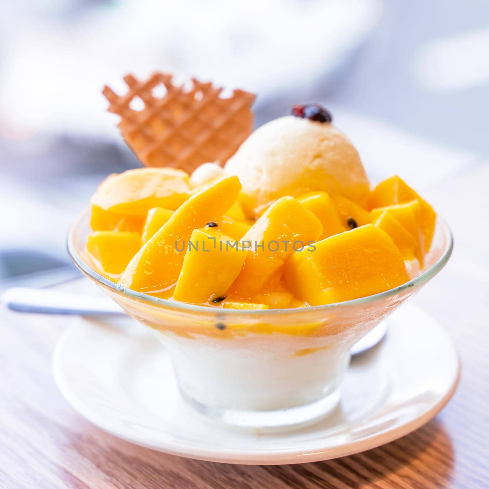 Fresh mango shaved ice with a scoop of ice cream and juice sauce in summer restaurant, lifestyle, popular food in Taiwan, close up.