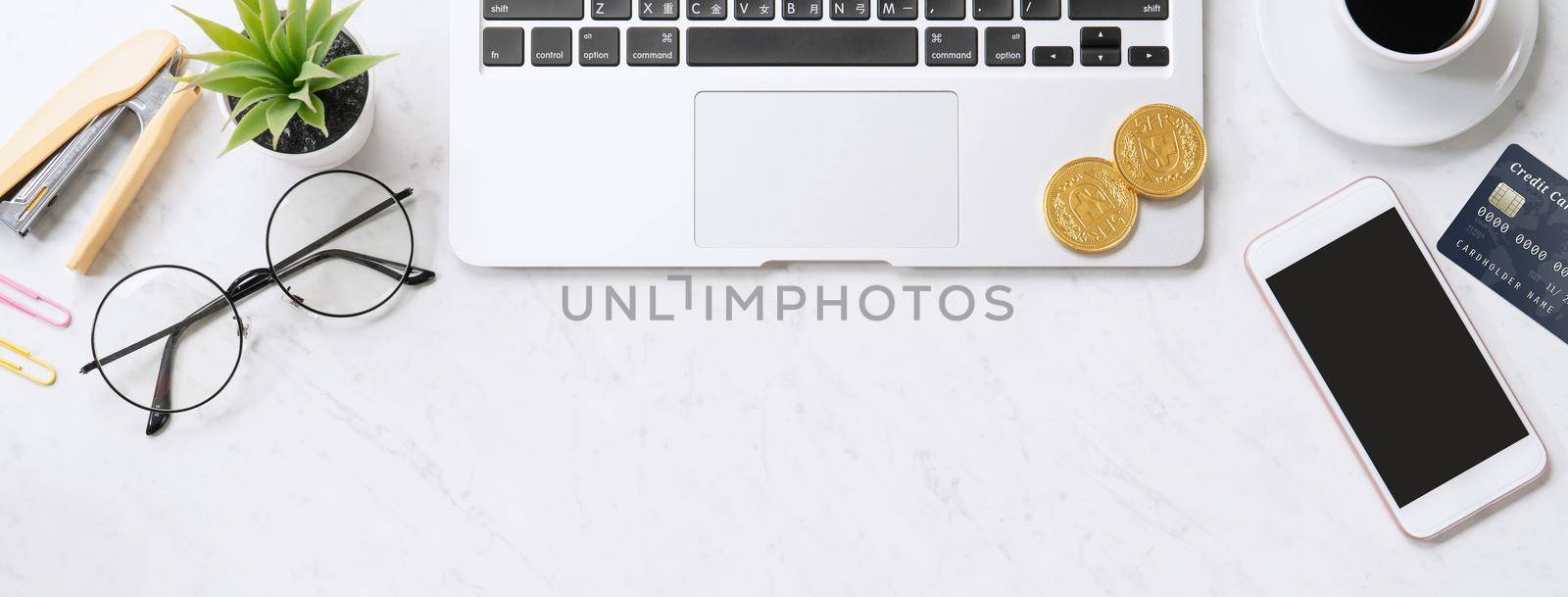 Concept of online payment with credit card with smart phone, laptop computer on office desk on clean bright marble table background, top view, flat lay by ROMIXIMAGE