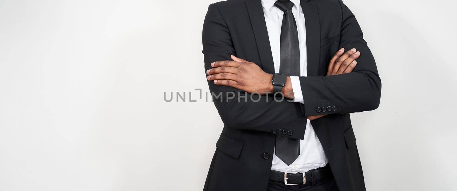Cropped portrait of successful african man with arms crossed over grey background with copy space by Mariakray