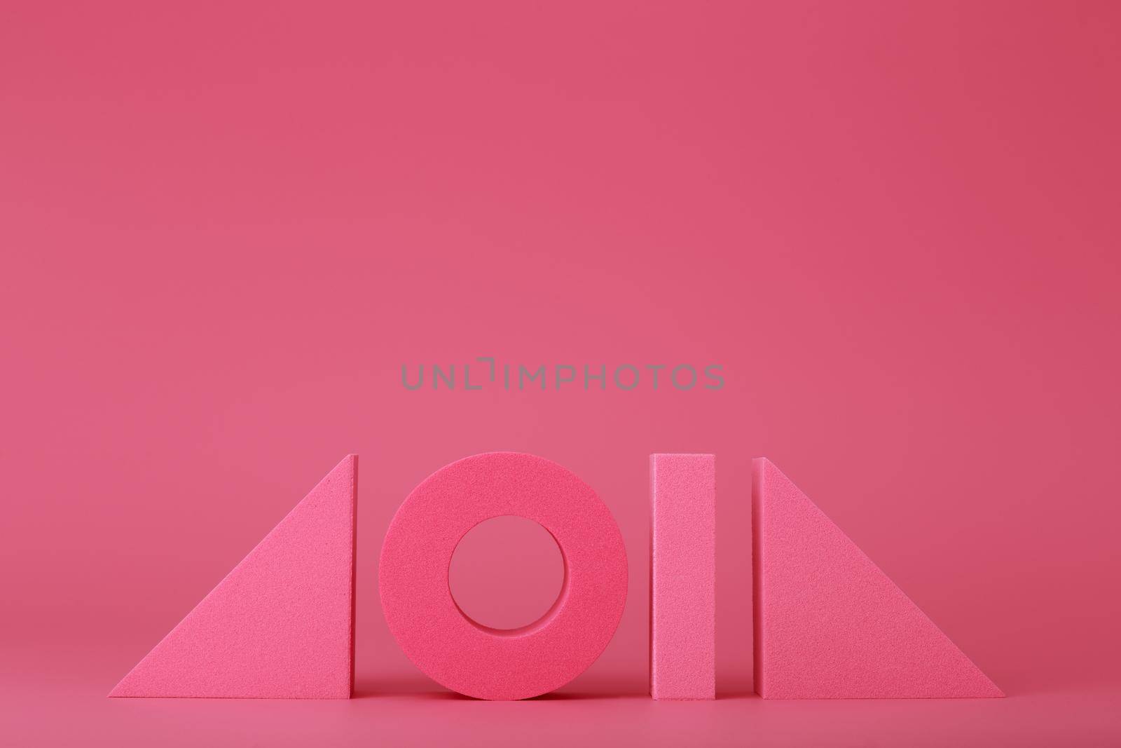 Pink futuristic background with geometric figures in a row with copy space. Concept of trendy abstract background