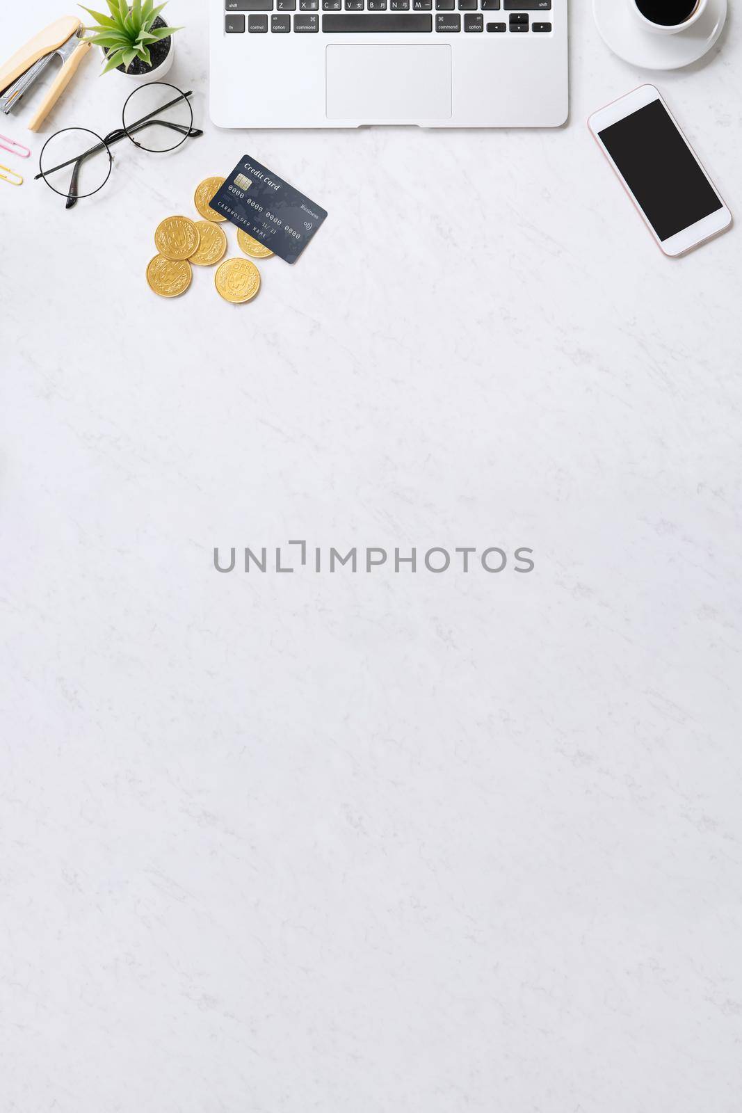 Concept of online payment with credit card with smart phone, laptop computer on office desk on clean bright marble table background, top view, flat lay