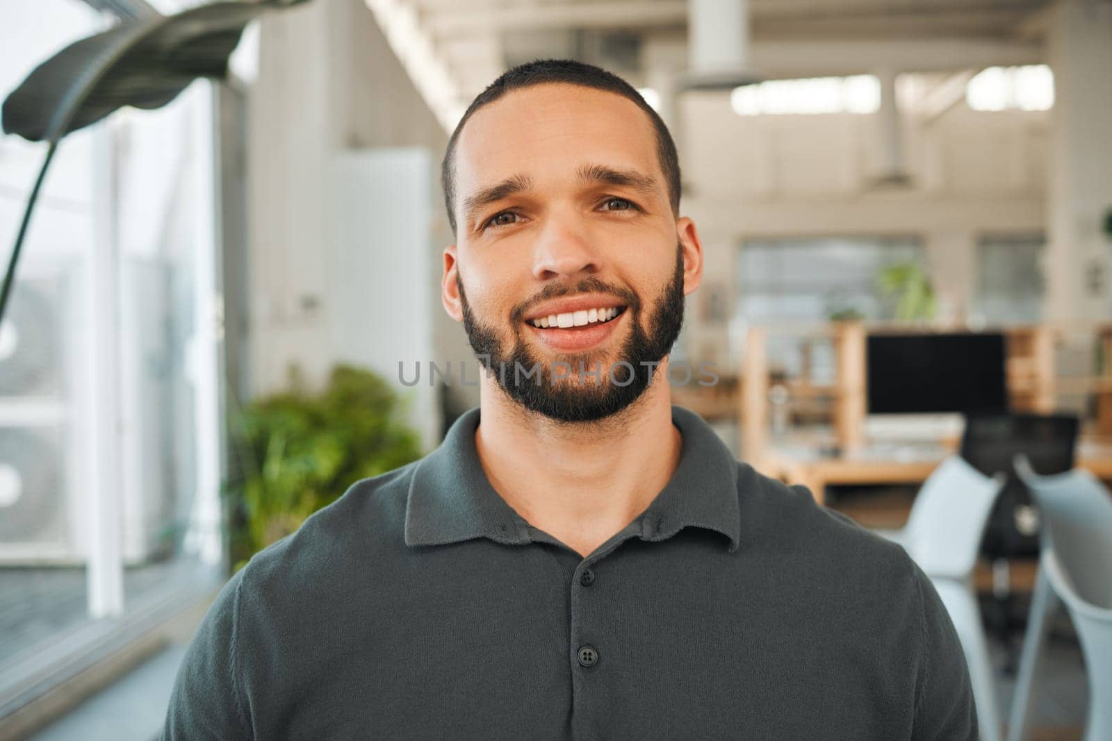 Portrait of handsome young businessman in his office. Mixed race businessman standing in his office. Headshot of a young architect in his office. Corporate creative in his agency.