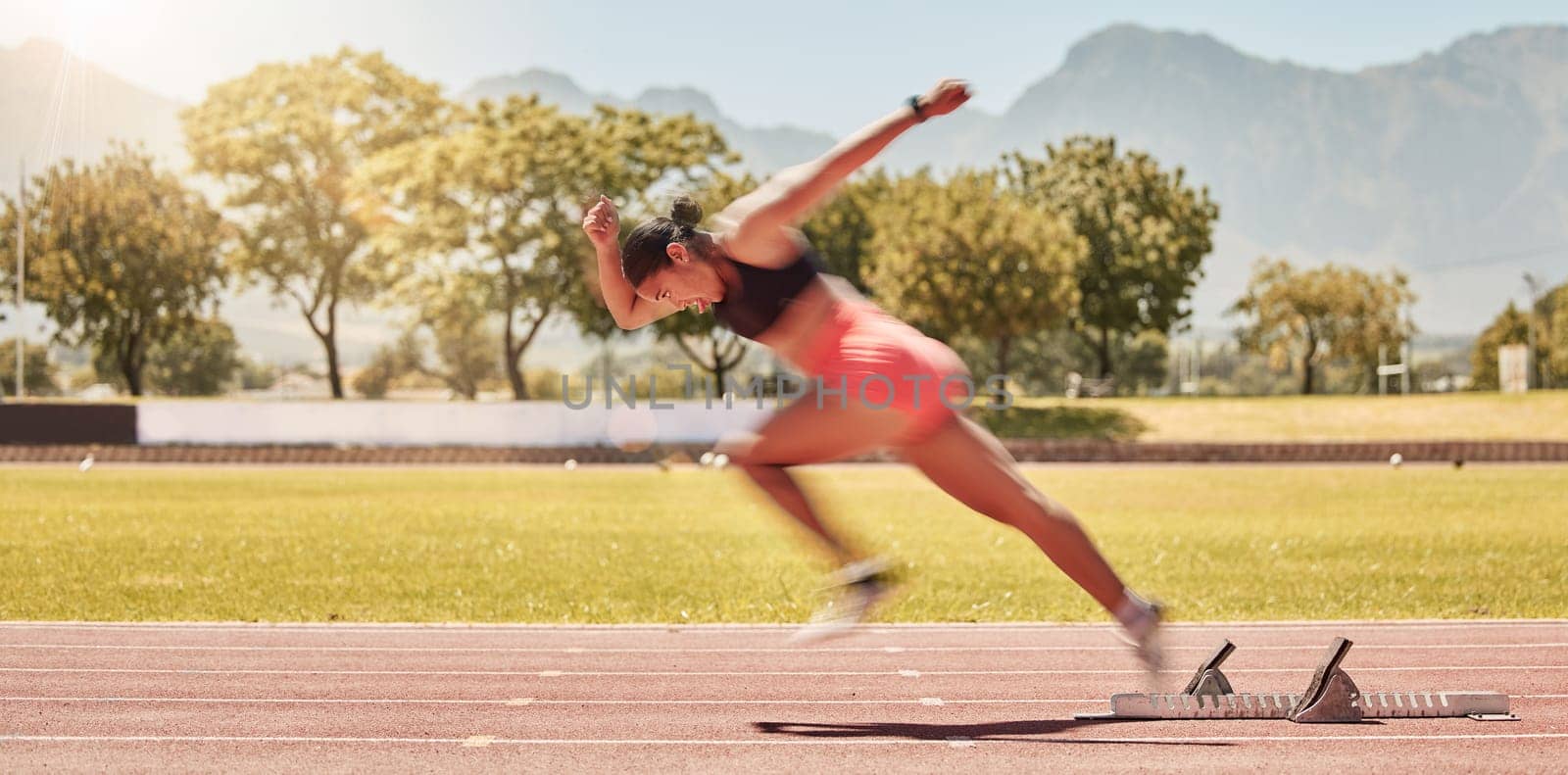 Sprinting, sports and woman training at a stadium for fitness, exercise and cardio with energy. Running, speed and athlete runner moving with power, fast and action for a race or competition.