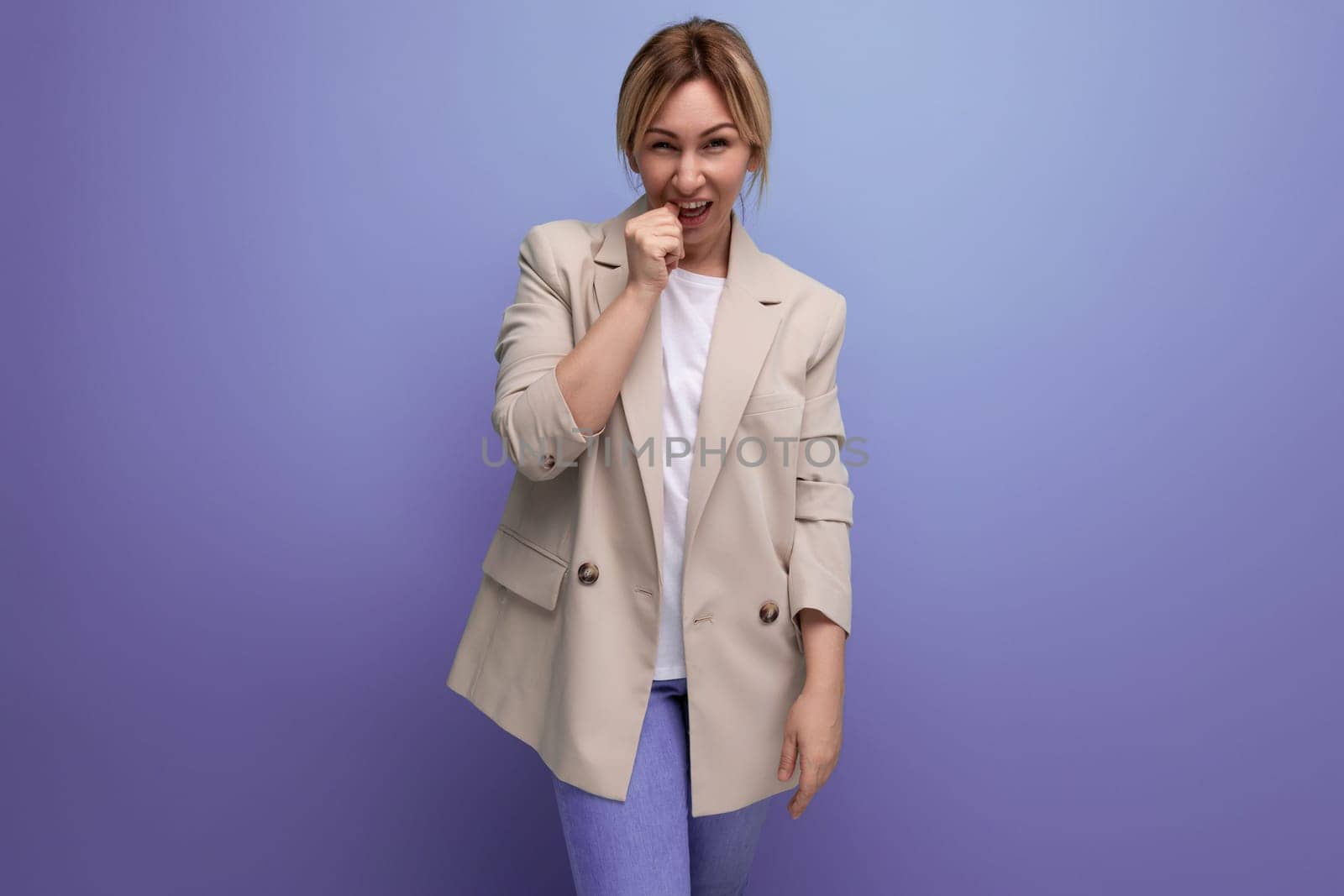 portrait of doubtful european blonde 30s business woman on studio background.