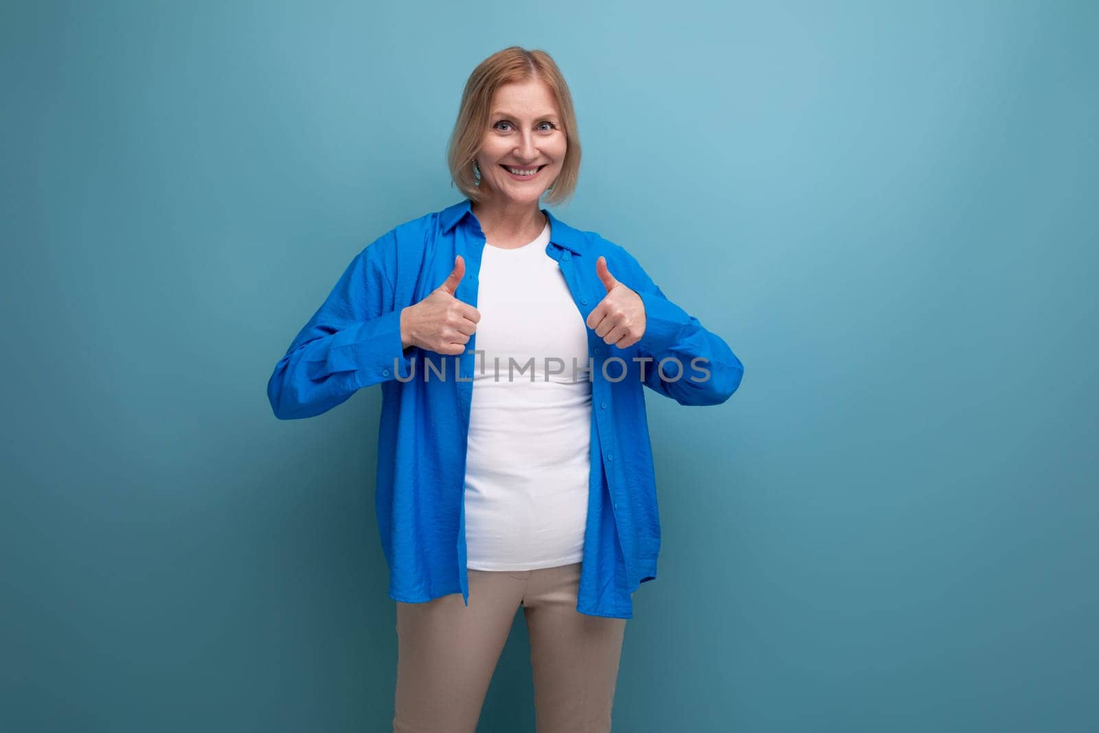 energetic 50s woman in an attractive look on a blue background with copy space.