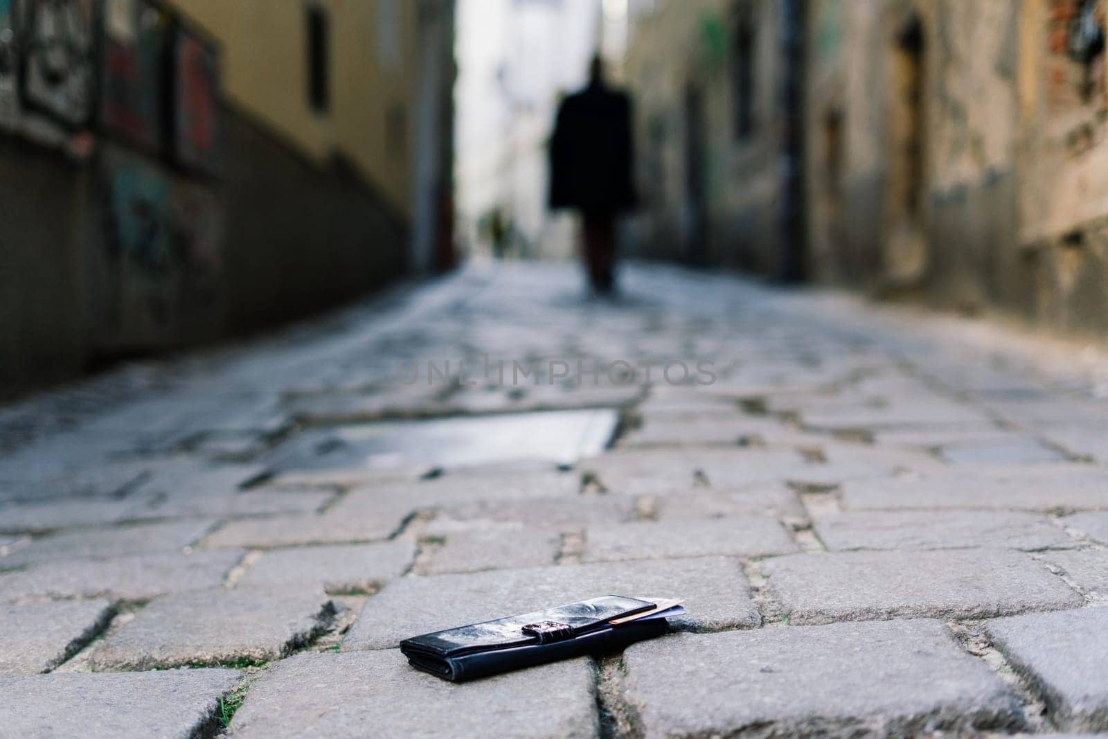 The wallet with coins on a sidewalk street, forgotten money