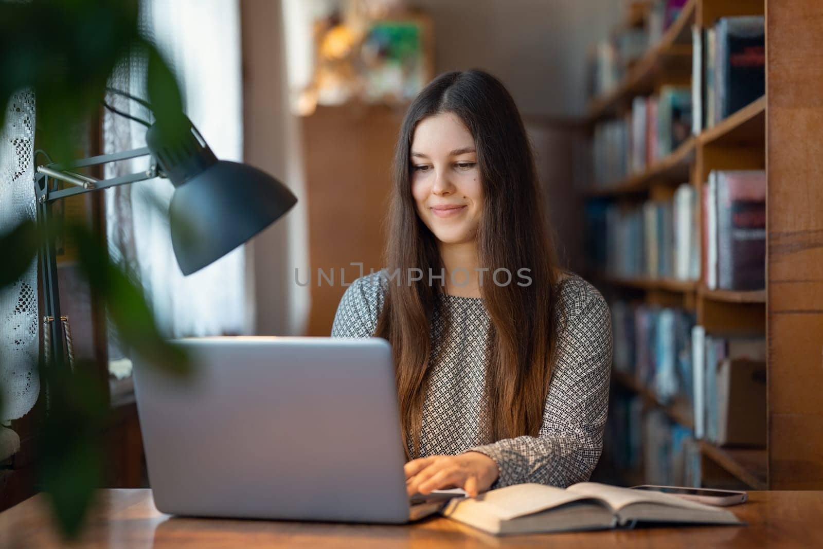 Student sitting at the desk, using laptop computer, getting knowledge with leisure and fun