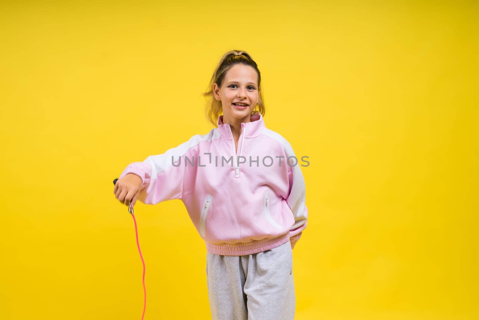 Adorable female child with skipping rope jumping in a studio