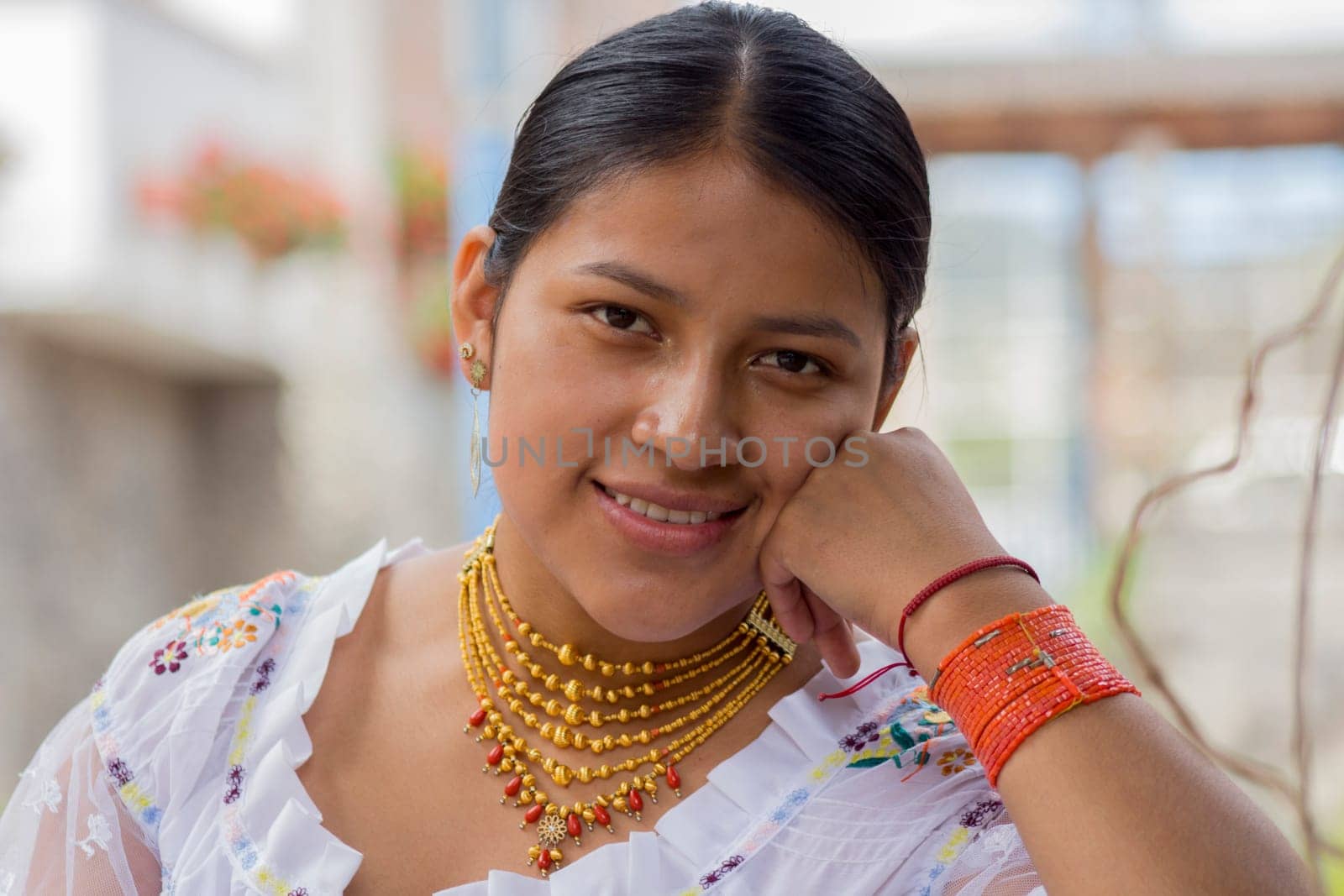 closeup of beautiful indigenous woman with traditional dress of her culture looking and smiling at camera by Raulmartin