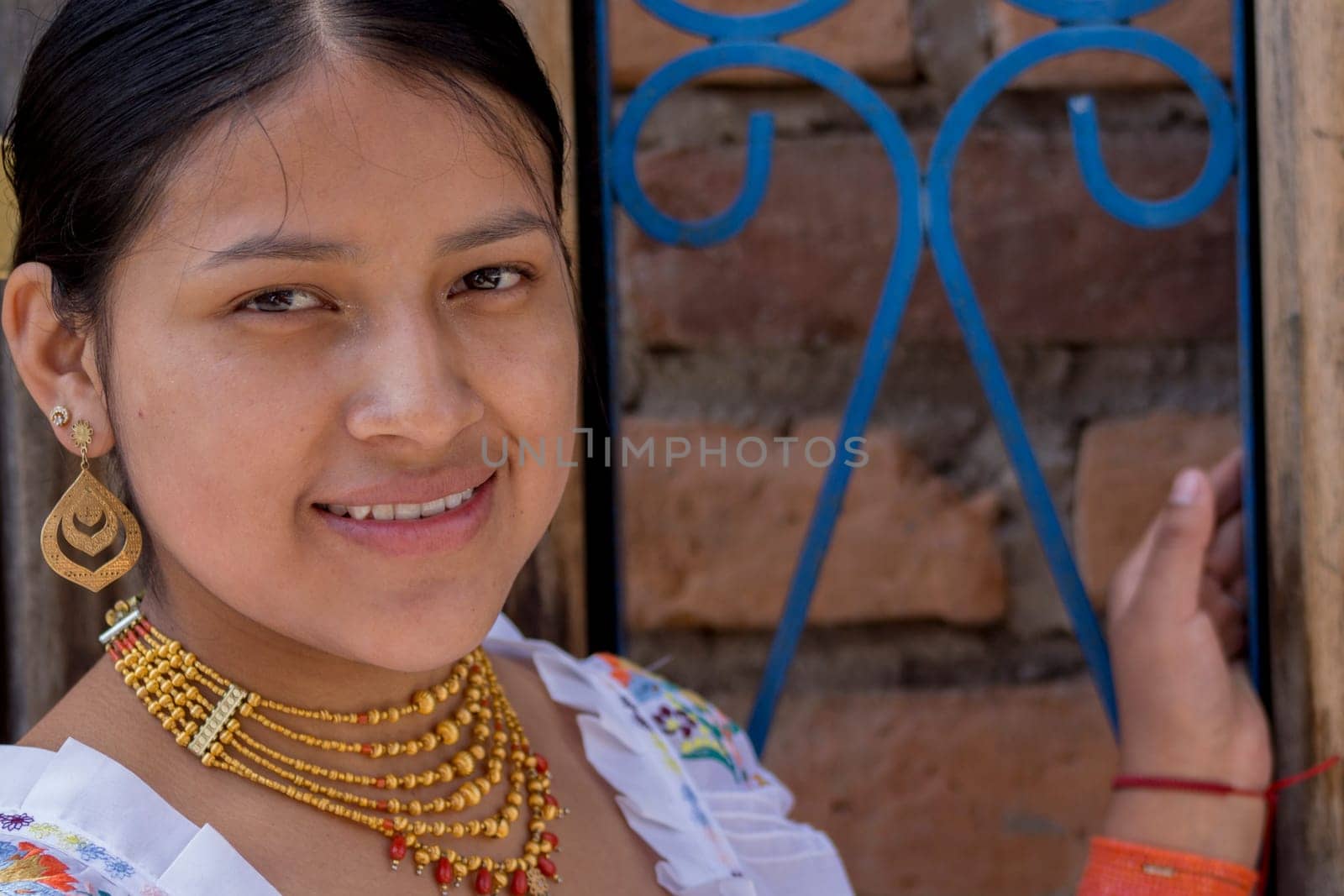 closeup with copy space of beautiful indigenous girl with dress from the native culture of ecuador next to a blue fence by Raulmartin