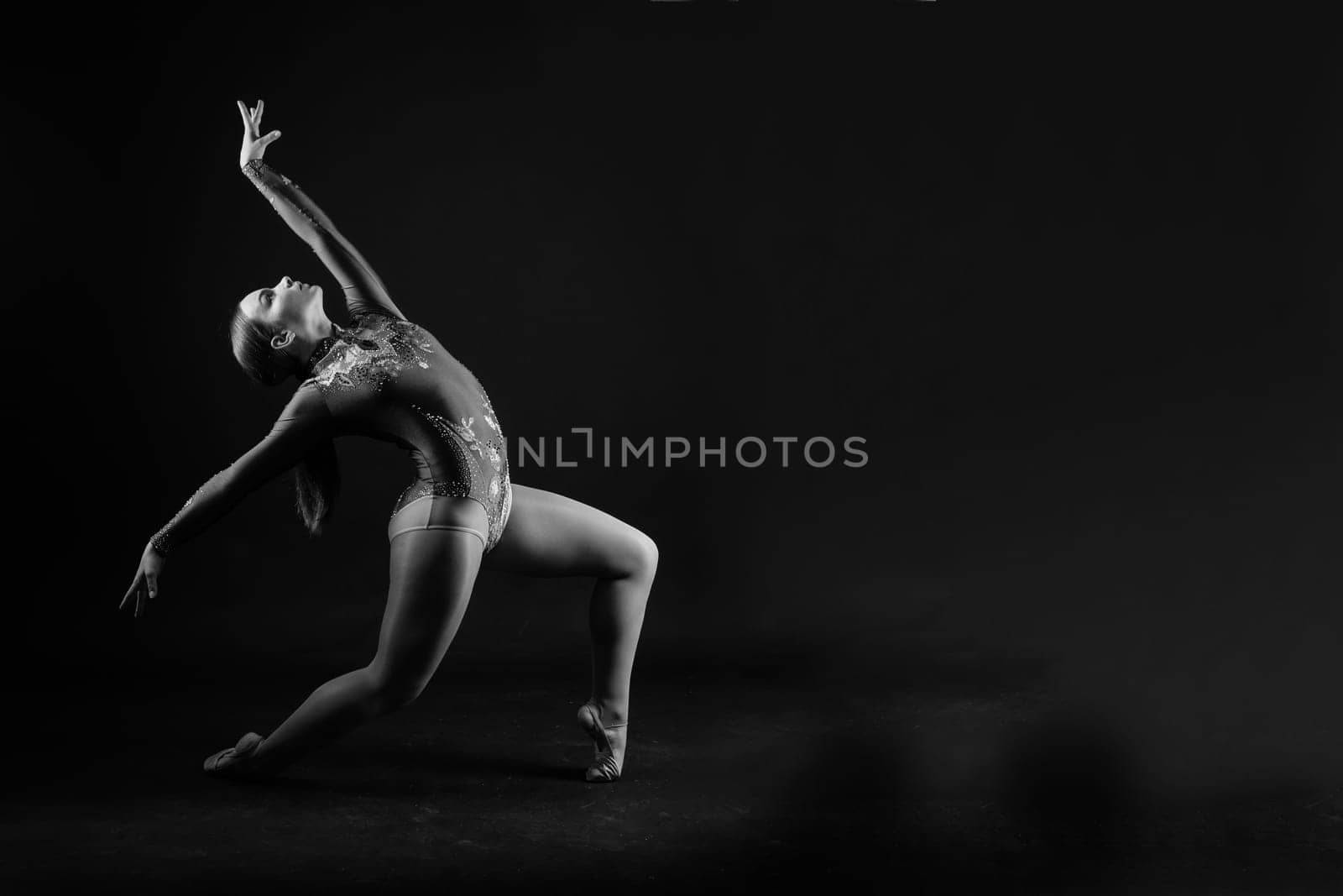 Beautiful cool young fit gymnast woman in a sportswear dress working out, performing art gymnastics