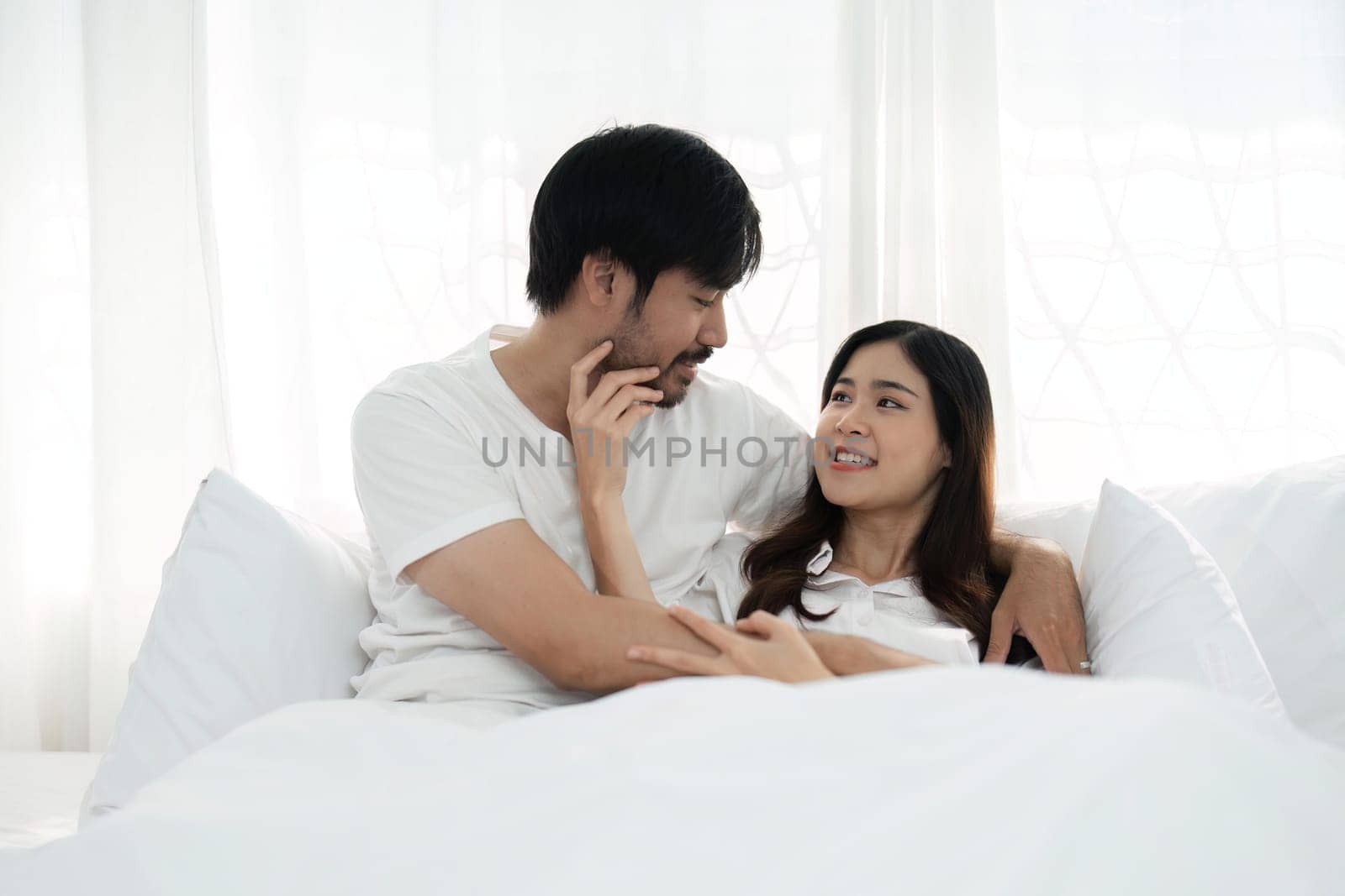 Young couple lying together in bed in the bedroom.