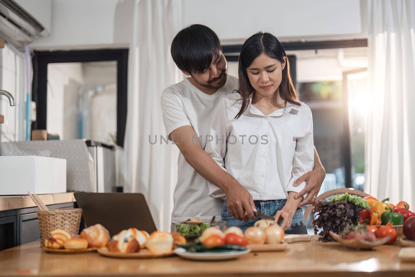 Happy couple cooking together and healthy eating concept - couple cooking food at home kitchen by nateemee