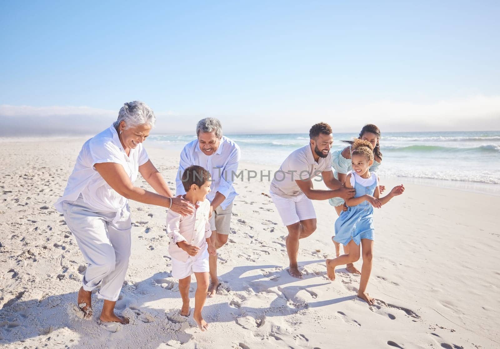 Travel, holiday and big family playing on beach for running and bonding on weekend trip. Happy, excited and children having fun with their grandparents and parents by the ocean on tropical vacation. by YuriArcurs