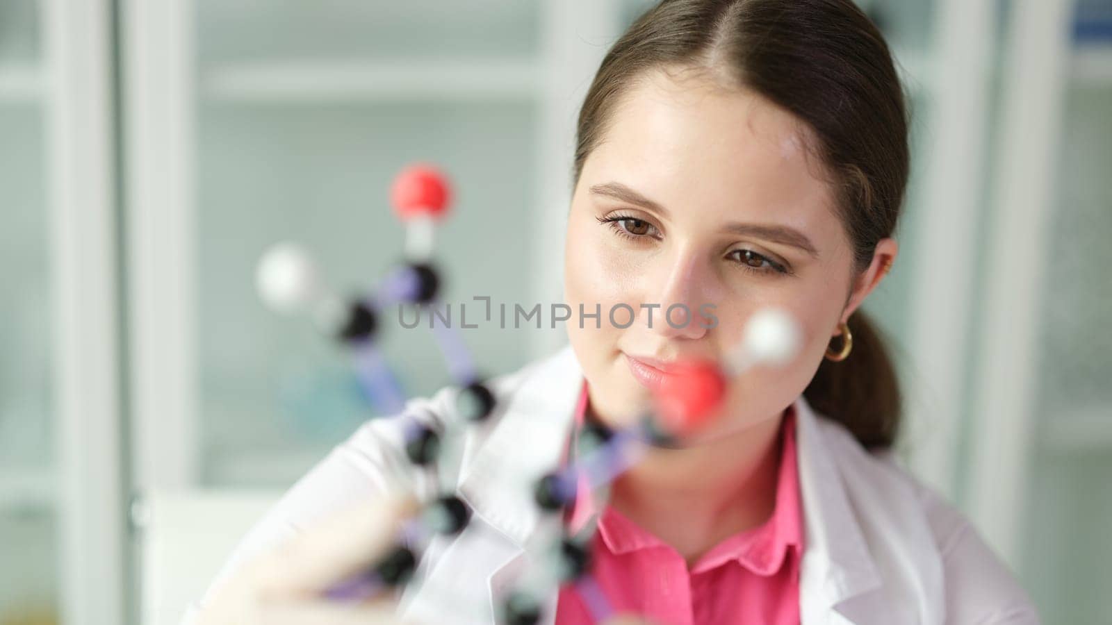 Woman scientist chemist studying molecule structure on plastic 3d model by kuprevich