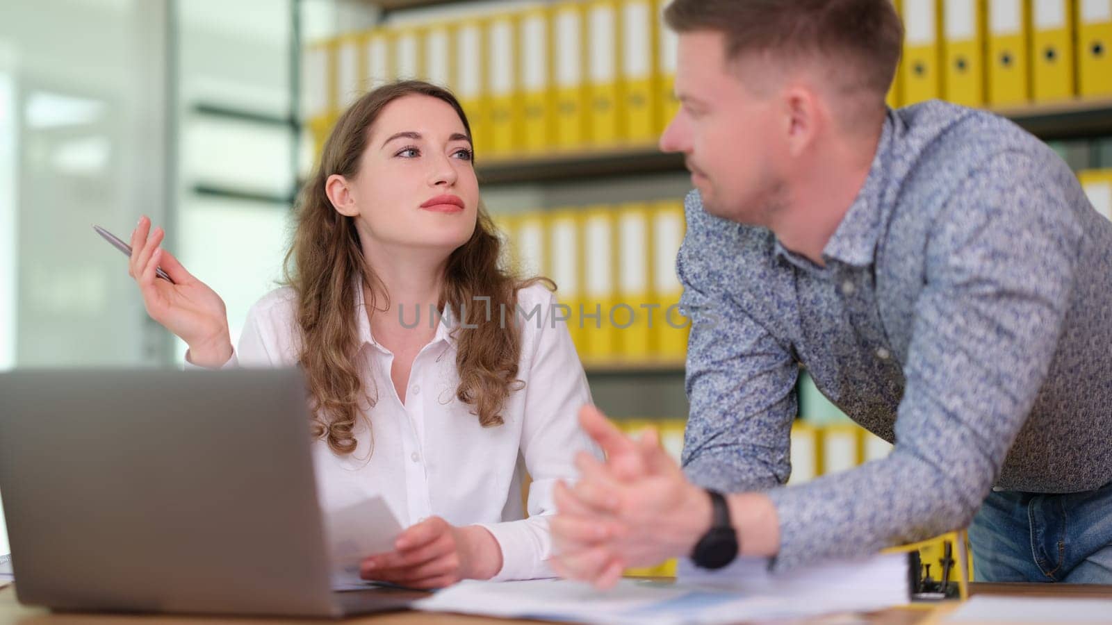 Business colleagues man and woman cooperating at table in office. Teamwork concept