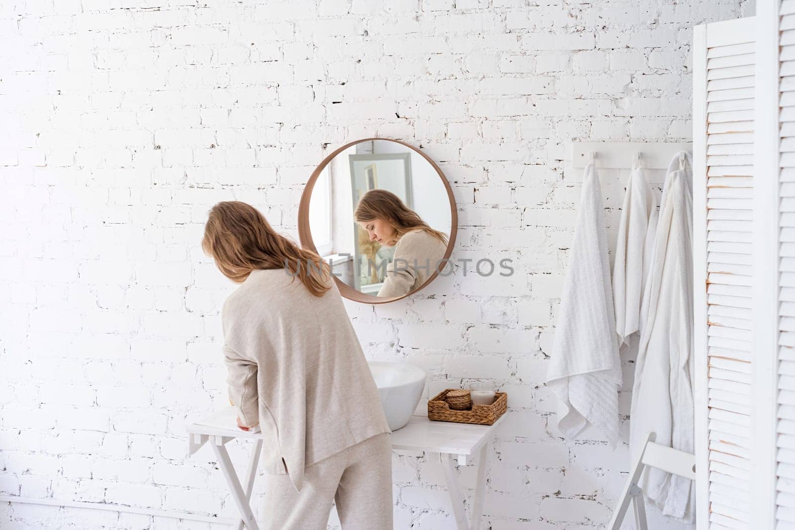 Woman looking at the mirror, making up in the morning by Desperada