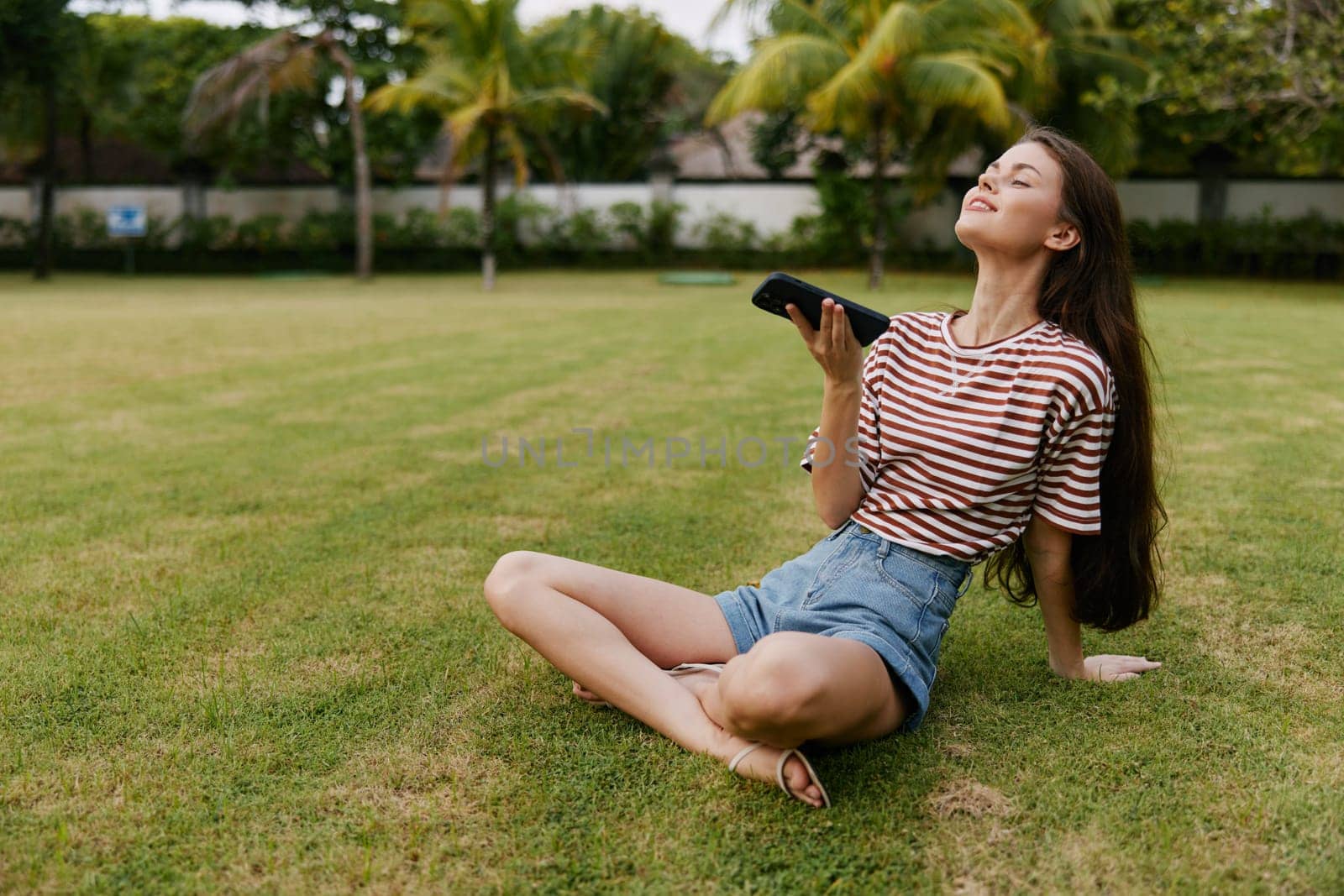 woman talking outside blogger girl grass phone application spring young app happy bag smiling beautiful palm tree lifestyle summer mobile nature park