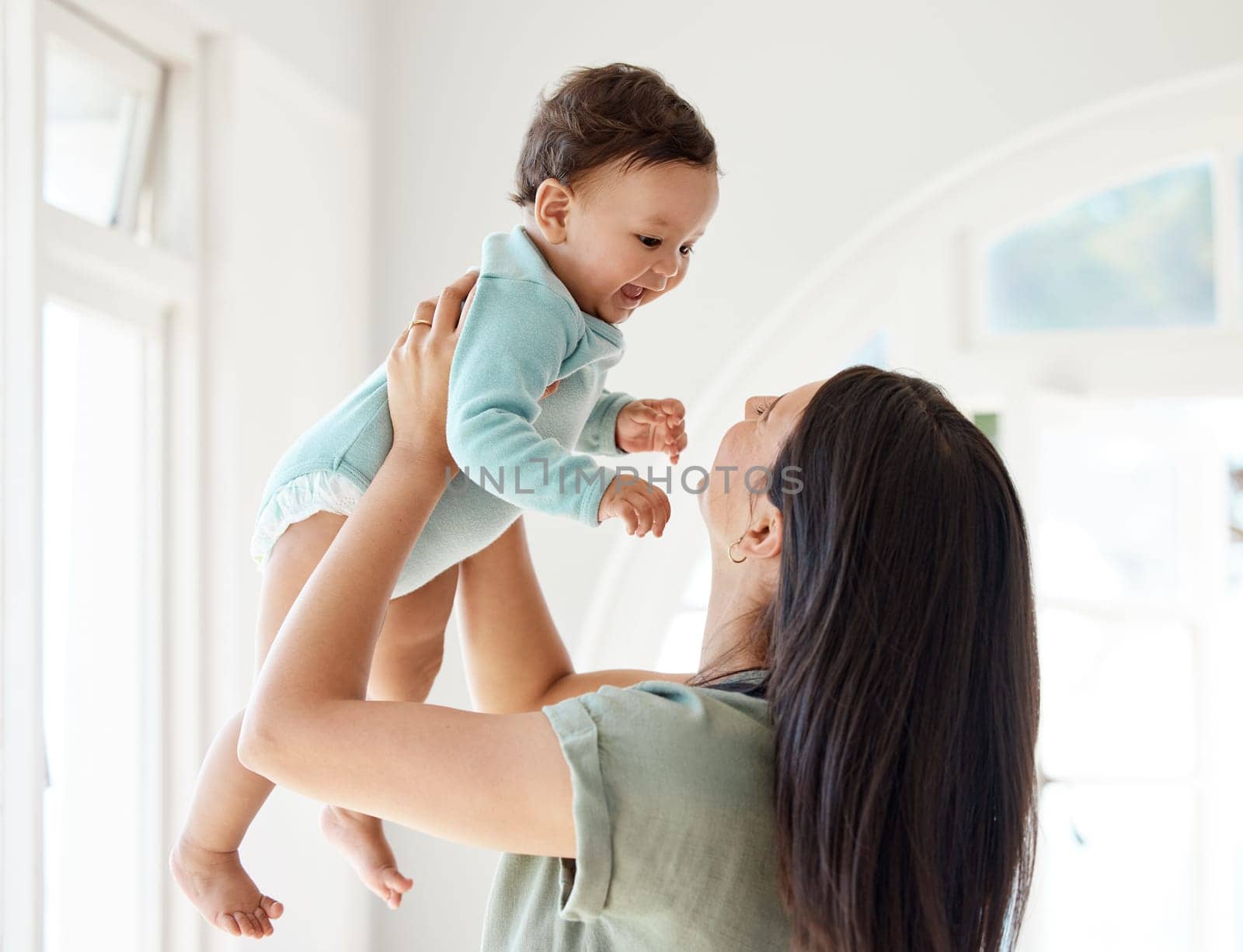 Mom carrying happy baby in home for love, care and quality time together to nurture childhood development. Mother, playing and holding infant kid for support, happiness and funny laughing in house.