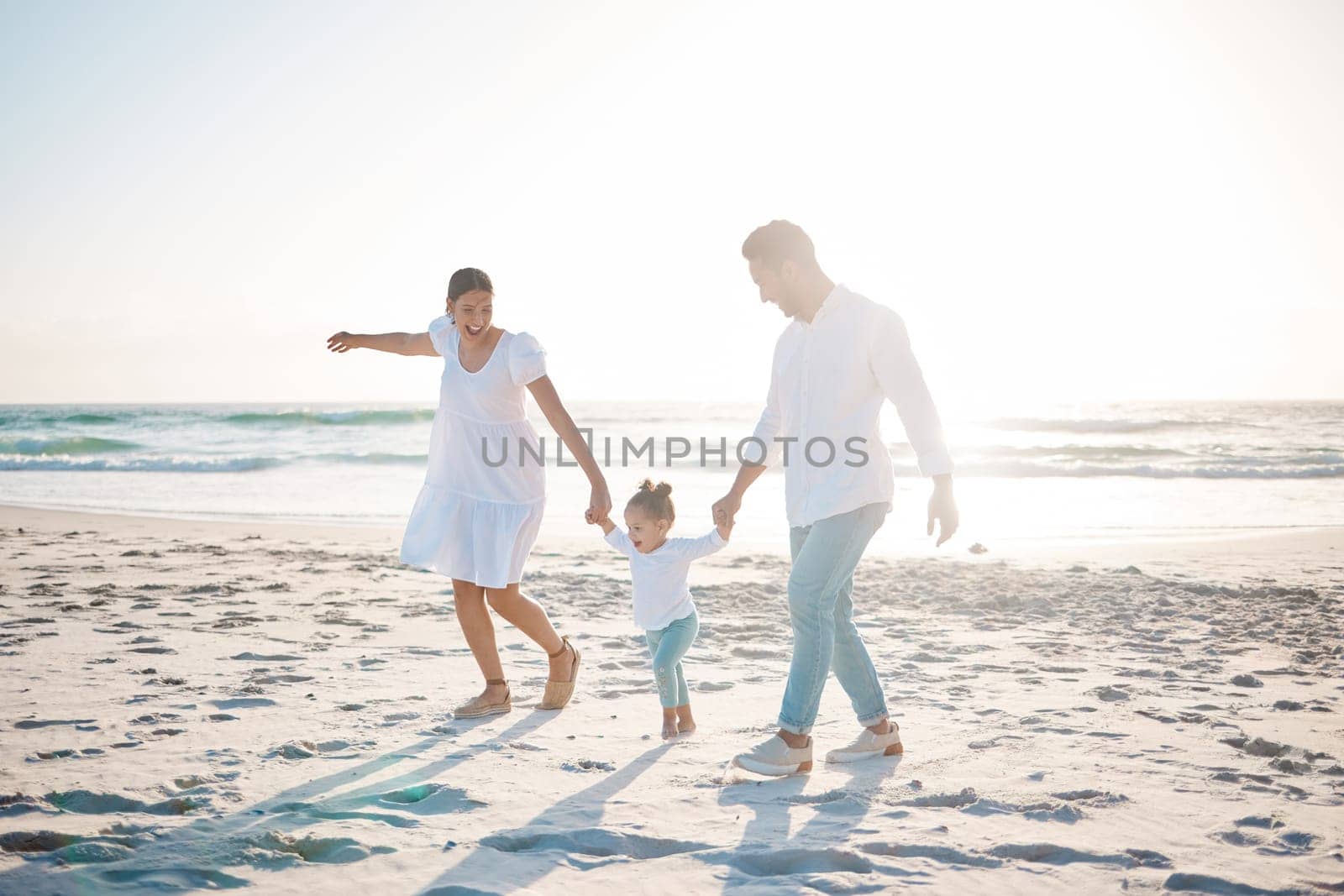 Happy family, holding hands and playing on beach with mockup space for holiday weekend or vacation. Mother, father and child enjoying play time together on ocean coast for fun bonding in nature.
