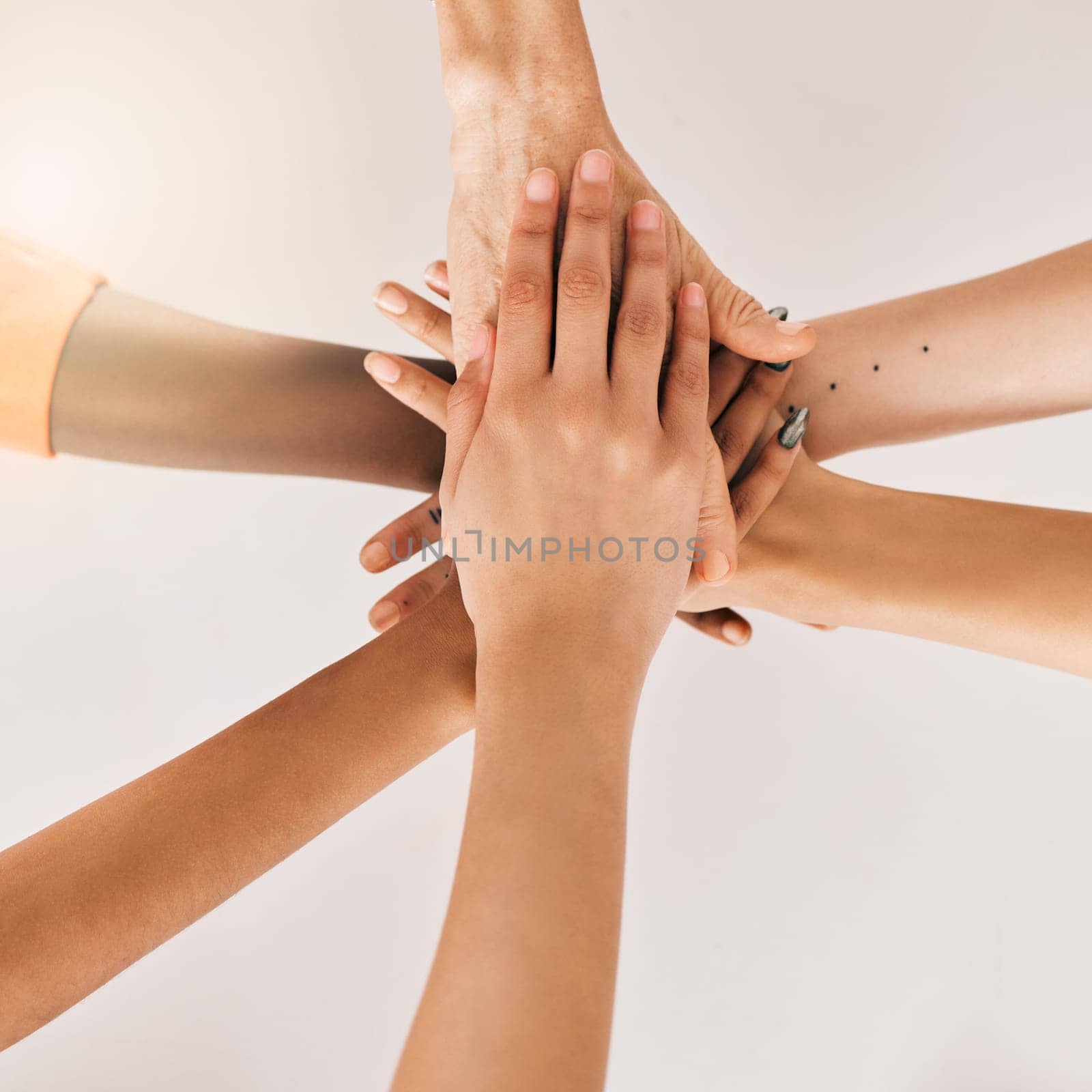 Hands stacked, teamwork and women in support, collaboration goals and community or solidarity from above. Circle, group of people and team work, faith or together sign isolated on a white background by YuriArcurs