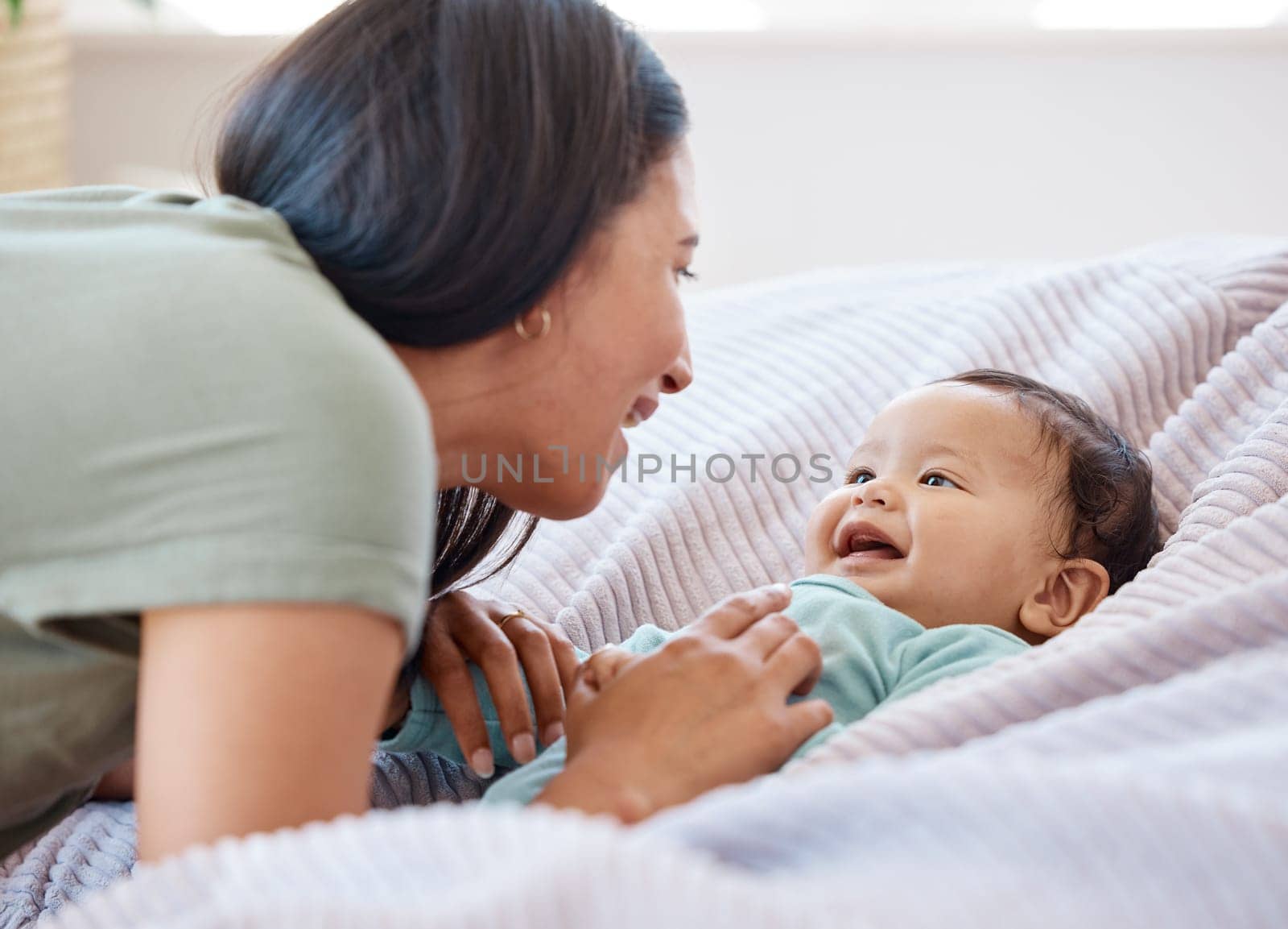 Mom, baby and laughing on bed in home for love, care and quality time together for play, growth and kids development. Happy mother, infant child and fun with newborn girl, relax and smile in bedroom by YuriArcurs