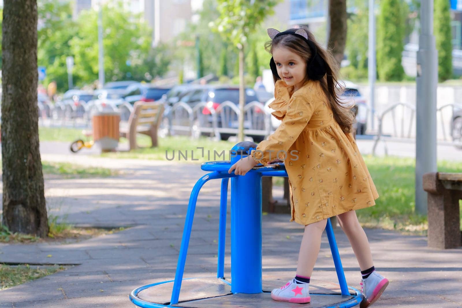 Happy little girl is playing on the playground in the park. by leonik
