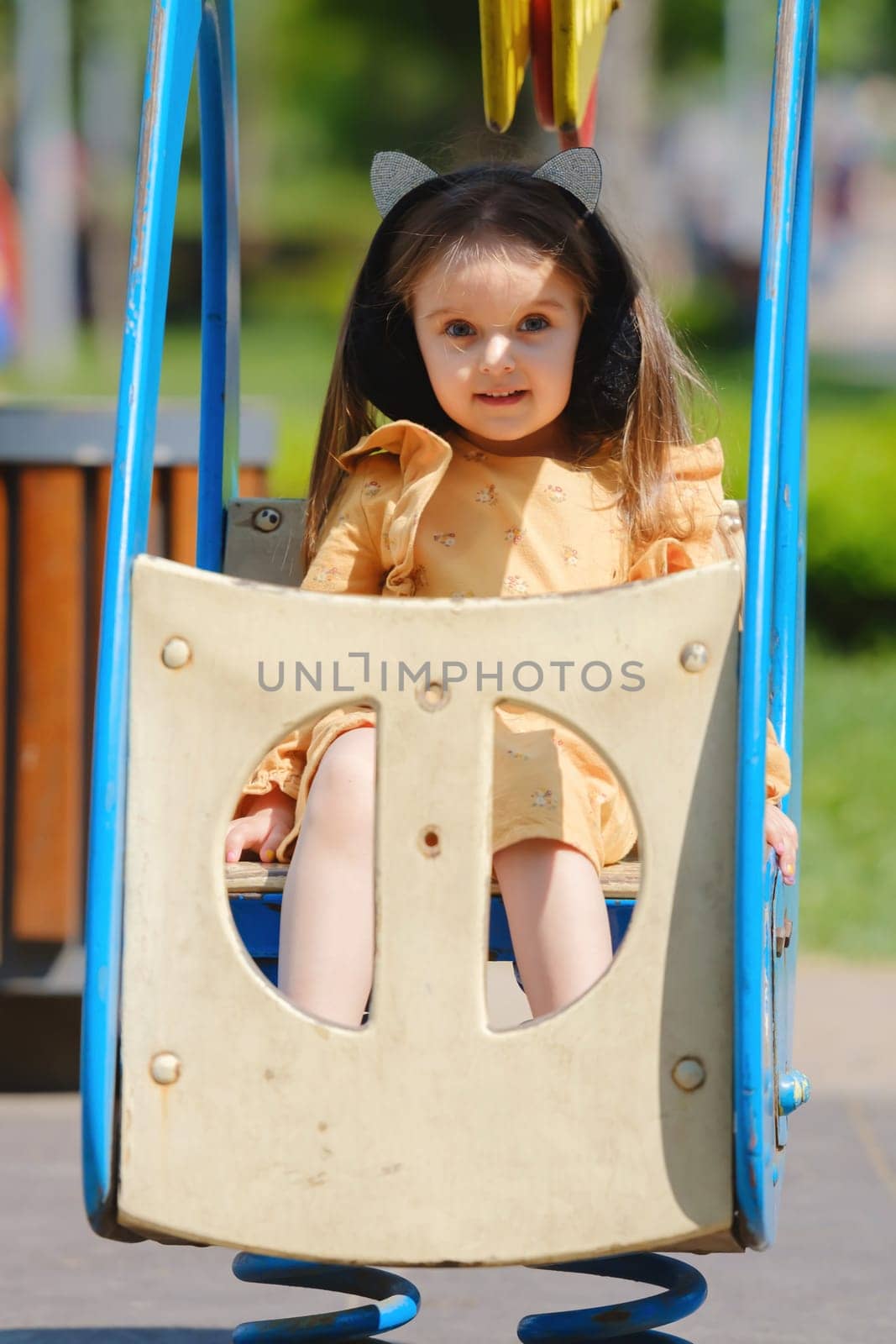 Happy little girl is playing on the playground in the park. by leonik