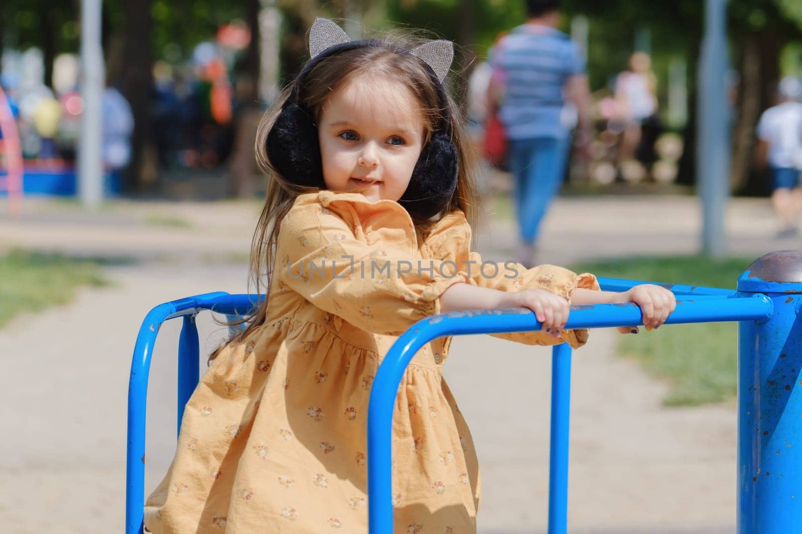 Happy little girl is playing on the playground in the park.