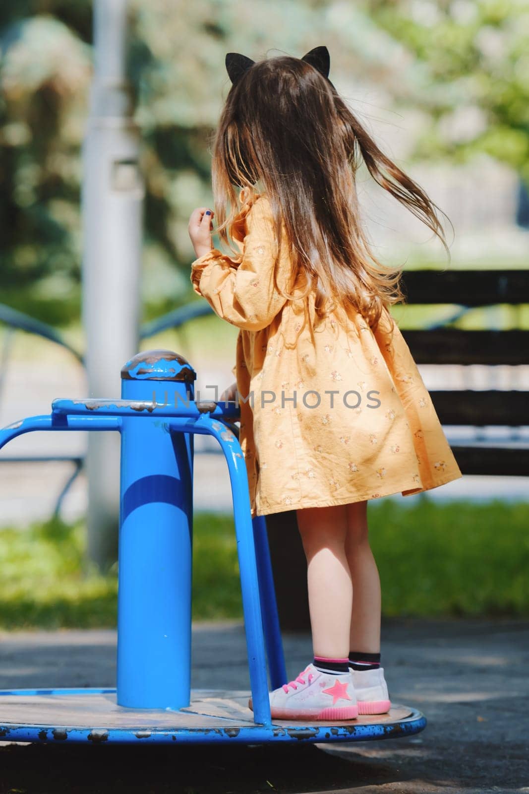 Happy little girl is playing on the playground in the park. by leonik